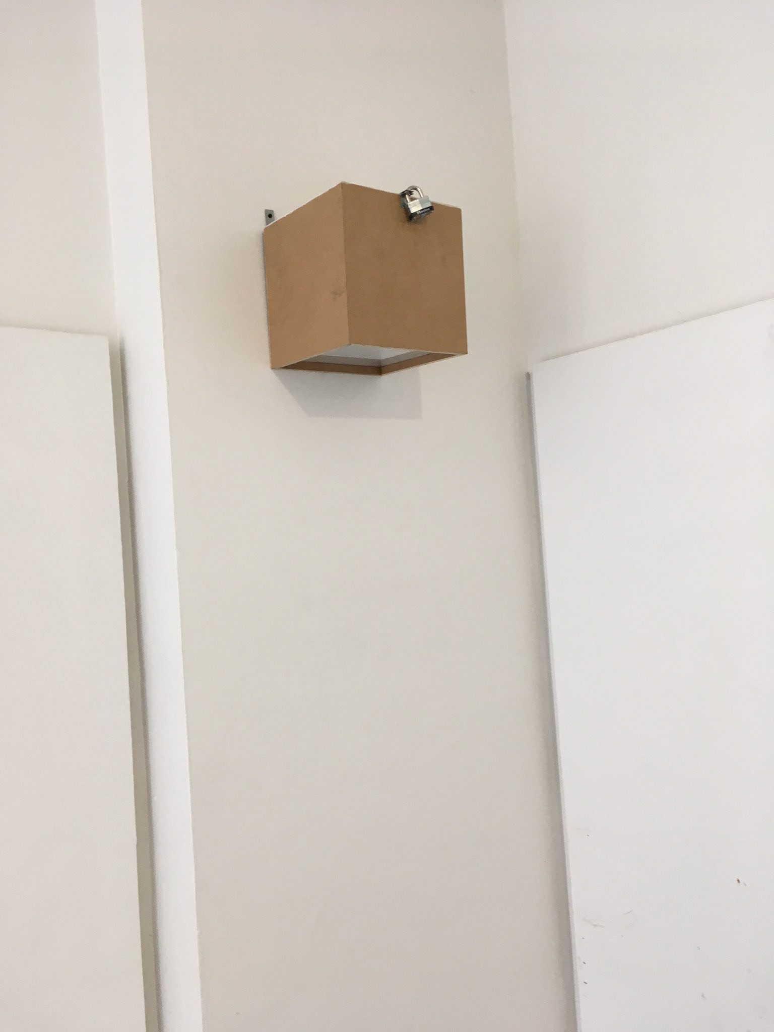 Austin Abistado, Untitled, 2018. MDO, white latex paint, plexiglass, Master Lock, galvanized steel, screws.