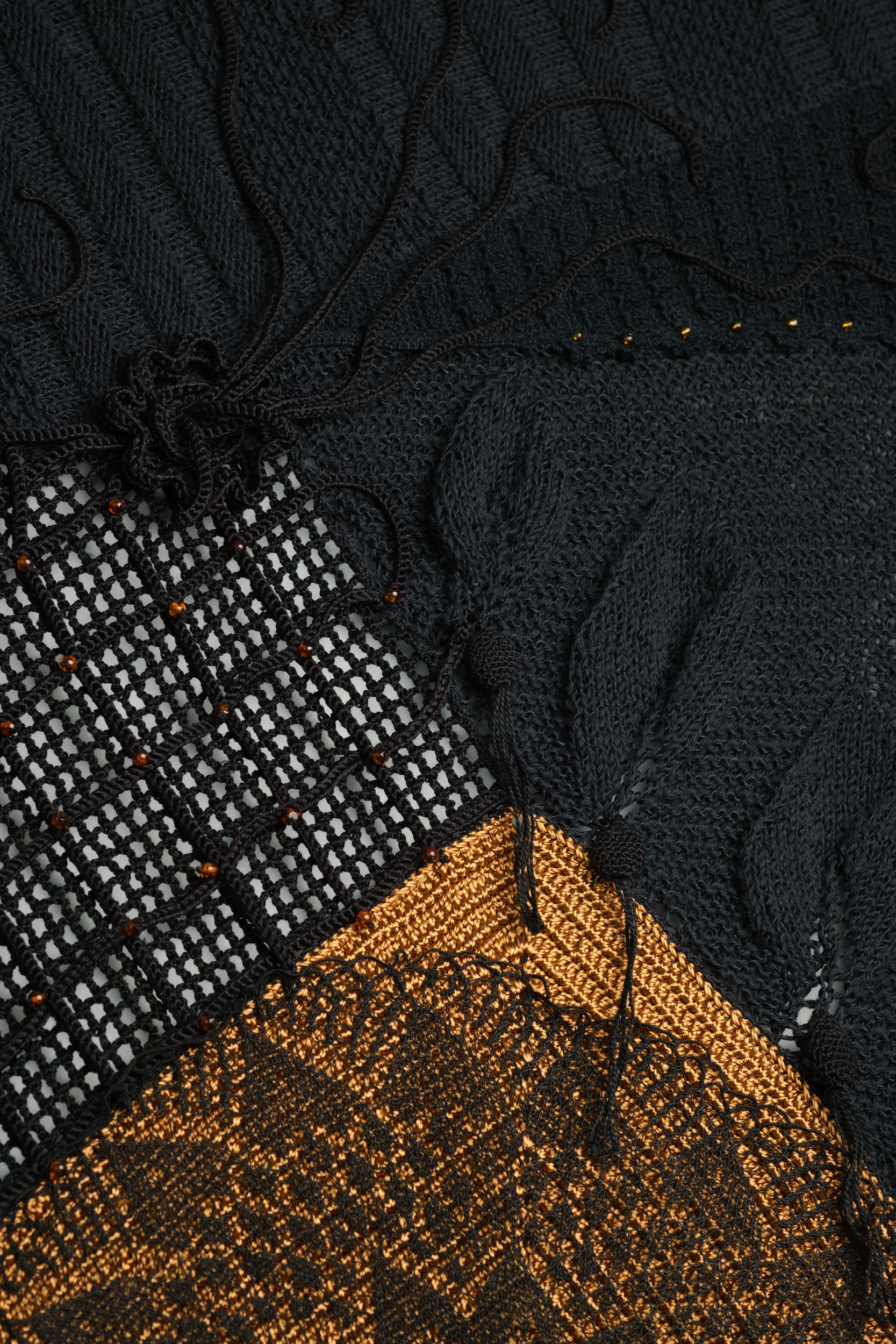 Detalhe da textura de "Desígnios", escultura têxtil de Cláudia Conde. Trama detalhada com fios em tons terrosos e crus, destacando técnicas ancestrais de tecelagem manual.