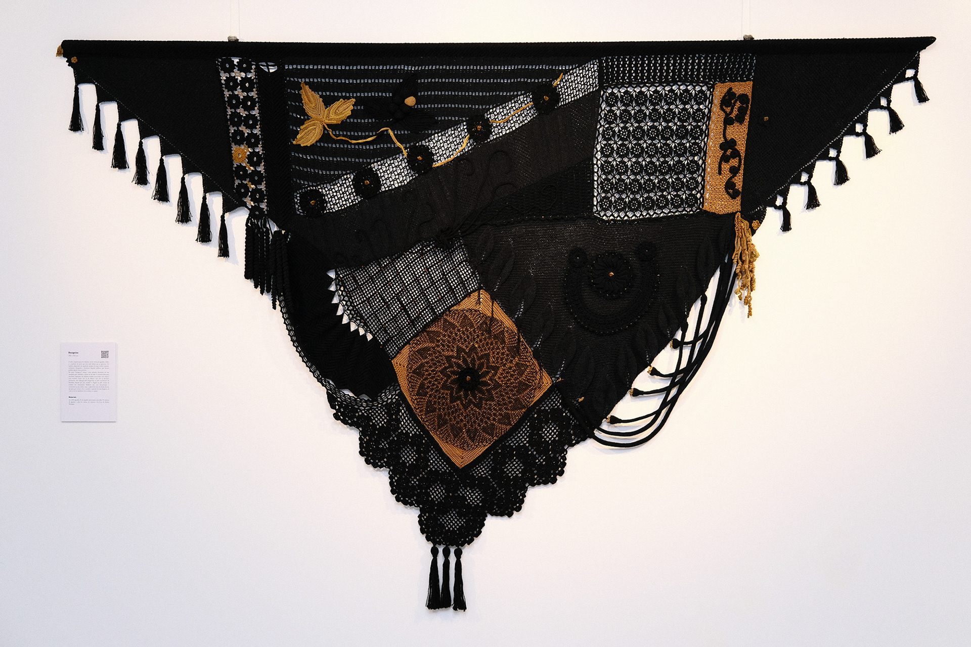 Escultura têxtil contemporânea "Desígnios" de Cláudia Conde. Obra em formato triangular inspirada no xaile tradicional, simbolizando a resiliência e emancipação feminina.