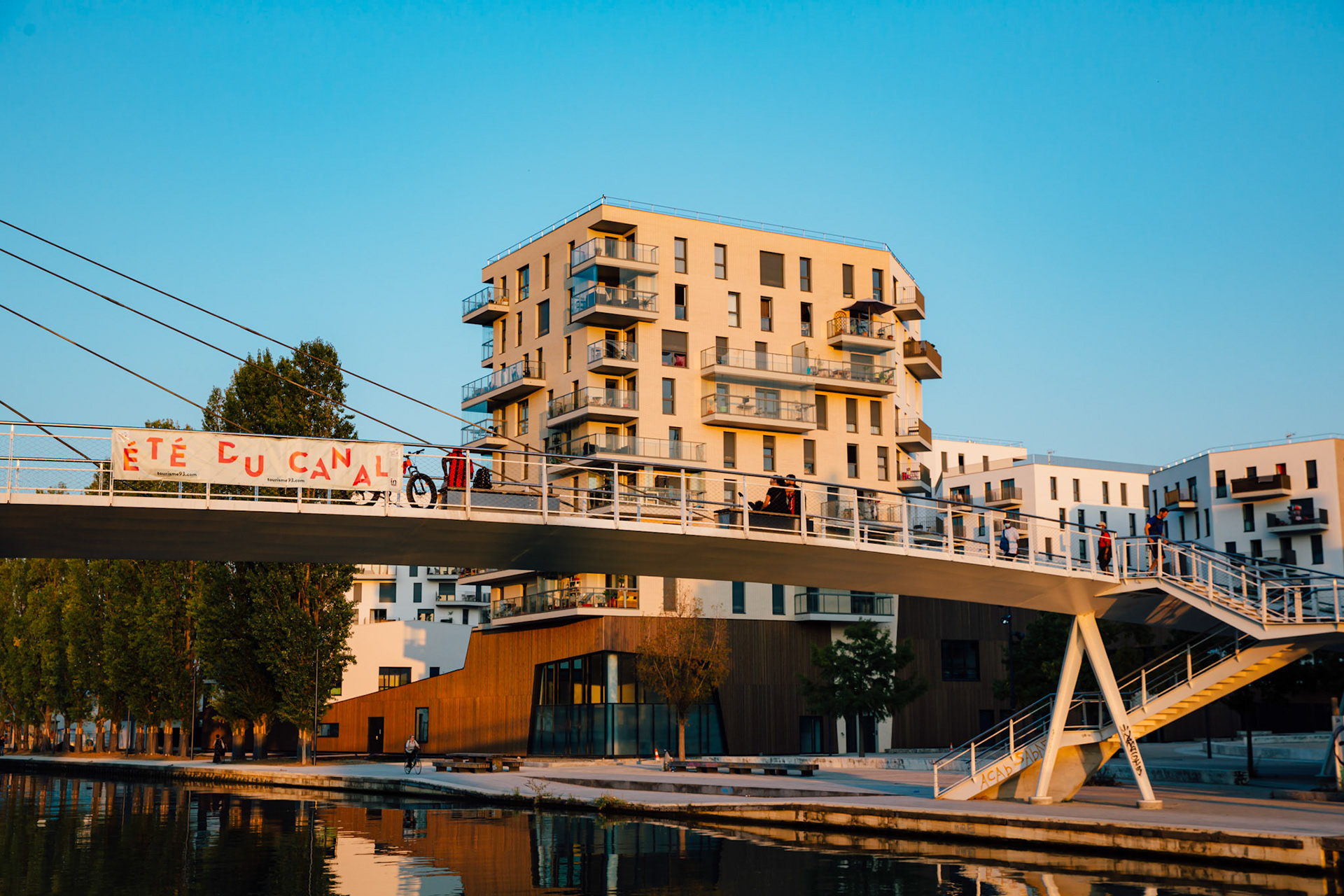 Le Canal, ce n’est pas uniquement des passerelles parisiennes datant d’un siècle. A Bobigny, les berges de l’Ourcq offrent un paysage radicalement différent de celui de Paris, bien plus moderne. La Passerelle Pierre-Simon Girard a été inauguré en 2014, elle relie le Parc de la Bergère à La ZAC Ecocité-canal de l’Ourcq. Sur l’emplacement d’anciens entrepôts, après une dizaine d’année de chantier, les habitants commencent à investir ce nouveau quartier.