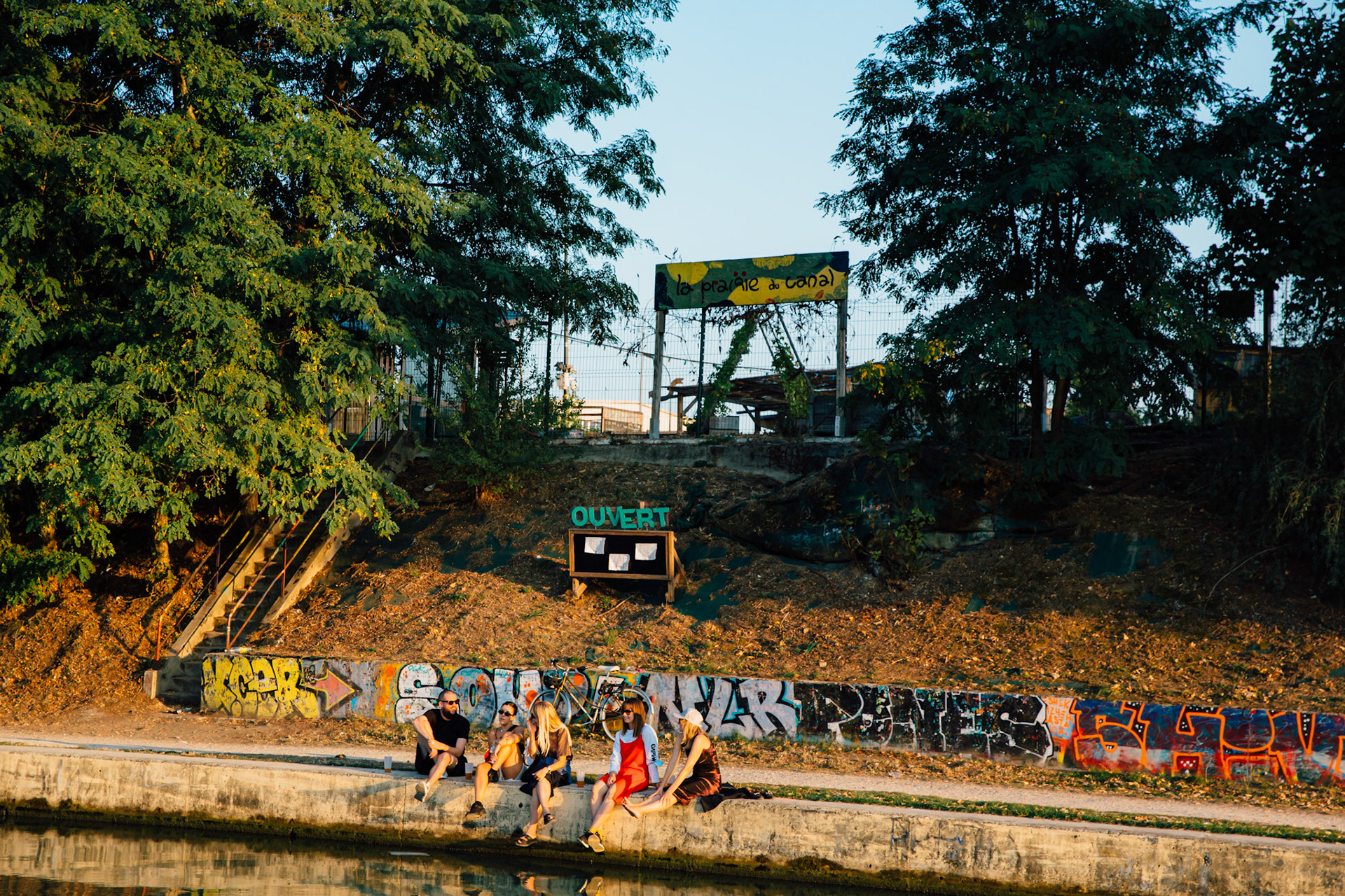 Arrivée à la Prairie du Canal, côté canal. Lieu alternatif de détente, festif, situé sur une friche. Si les immeubles de Bobigny ne ravissent pas le regard pour leur urbanisme utopique du siècle dernier, les alentours du canal offrent de larges aires de promenades, et de quiétude. Relativement proche d’un arrêt de la ligne 5 du métro, les parisiens n’hésitent pas à franchir le périph pour des soirées dépaysantes.