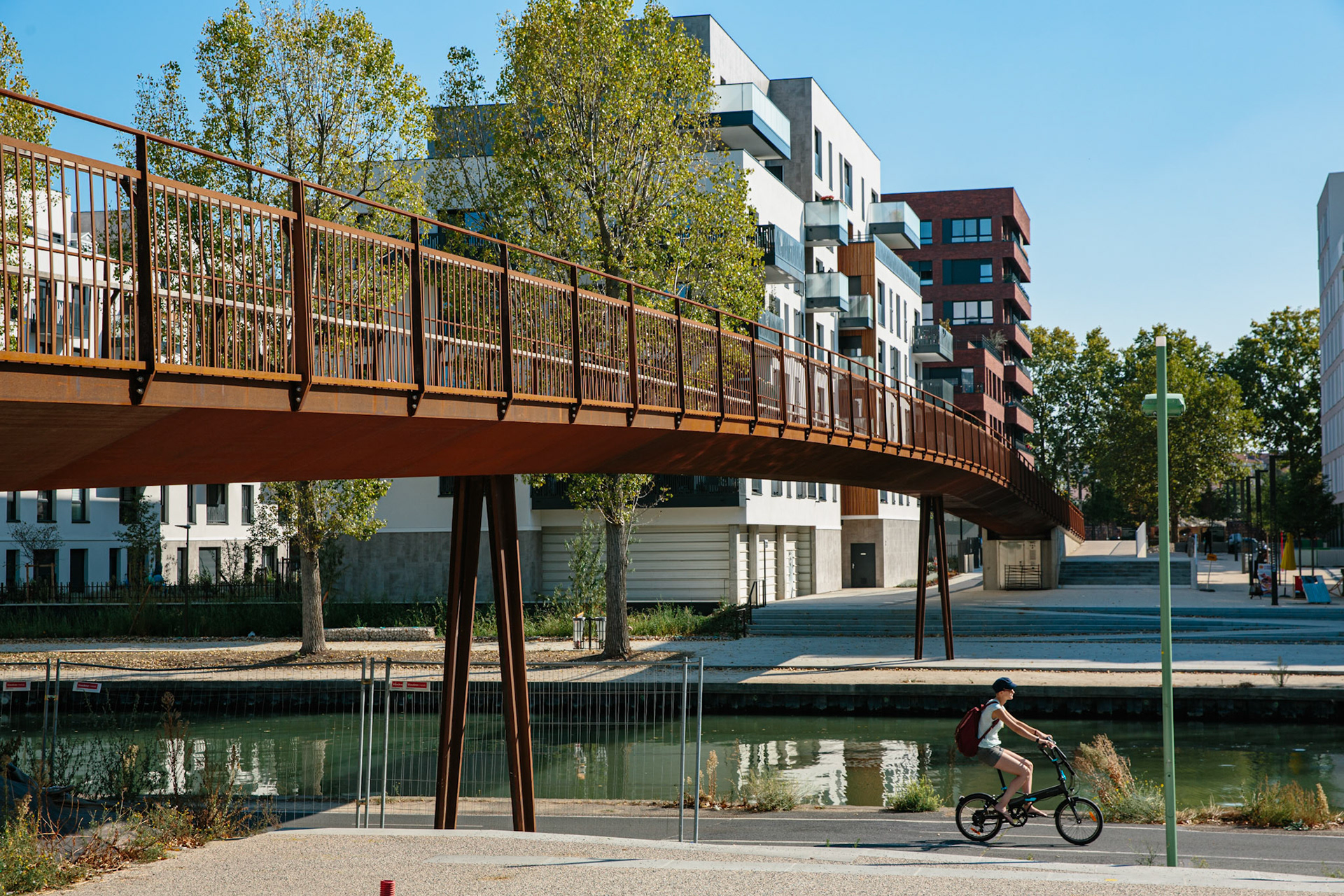 La passerelle piétonne Romy Schneider à Noisy-le-Sec est inaugurée le 30 novembre 2019. Située à quelques centaines de mètres de la passerelle Pierre-Simon, quelques barrières métaliques de chantiers subsistent toujours. Les alentours sinueux de la passerelle sont pensés pour l’accessibilité. Pour l’anecdote, la passerelle vient s’insérer dans un parking désaffecté où j’ai passé mon extension de permis B pour 2 roues en 2016, le décor a depuis bien changé.
