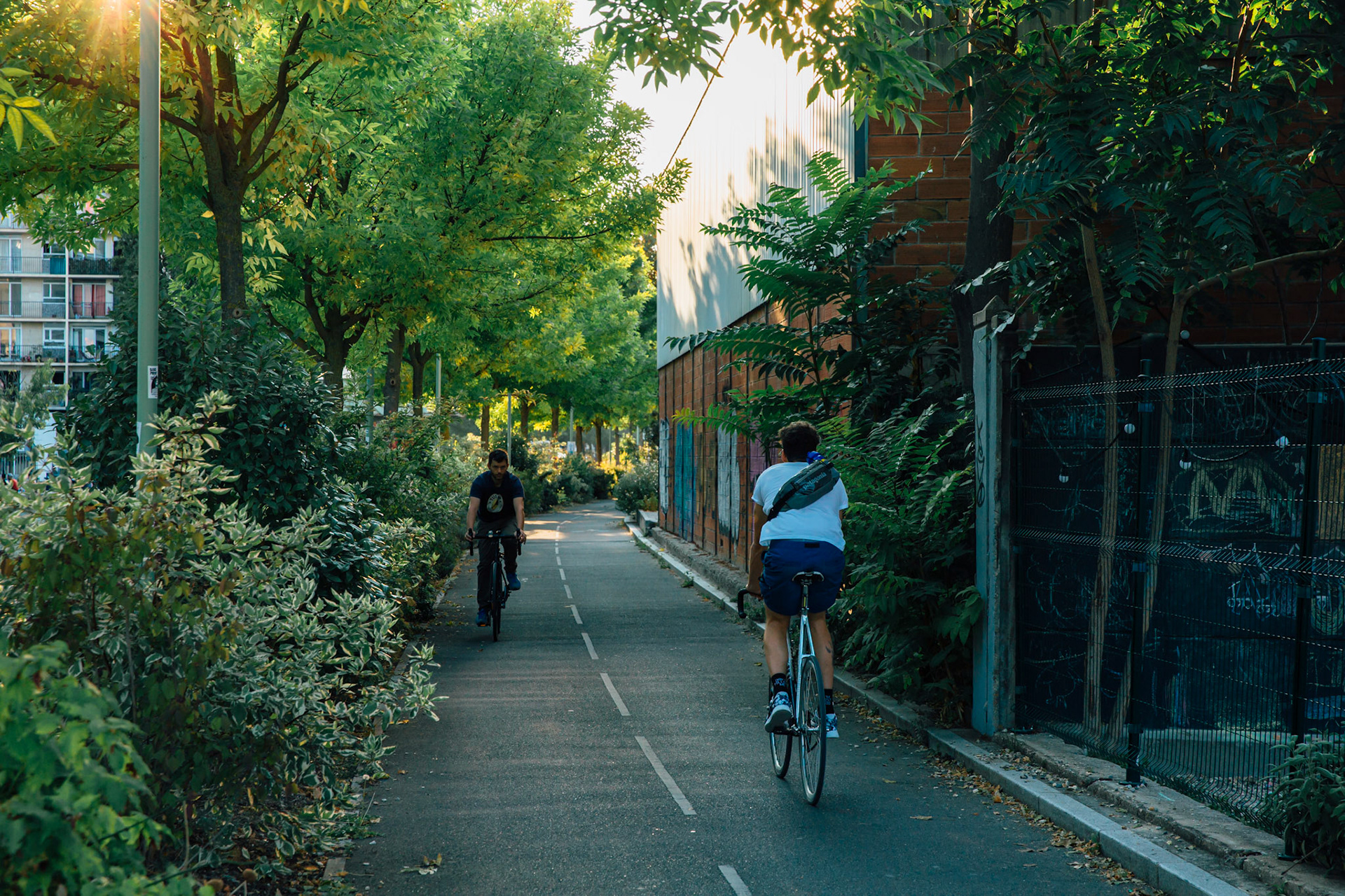 Chemin de Halage à Pantin, les vélos cheminent à travers la végétation. Les lampions de la Guinguette Des Grandes Serres vont bientôt s’allumer ✨