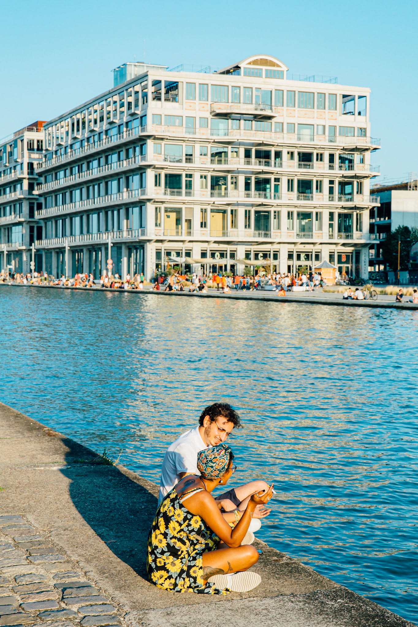 Il y a foule. Les magasins généraux étaient des entrepots industriels pendant tout le XXe siècle. Le batiment est resté inoccupé de 1995 à 2012. Quand j’étais à vélo, enfant, sans en connaître l’histoire, c’était un repère visuel emblématique à Pantin, je savais que je m’approchais de Paris. Les graphitis multicolores ont laissé place à une splendide façade monochrome, et la vie nocturne ressemble à s’y méprendre à Paris.