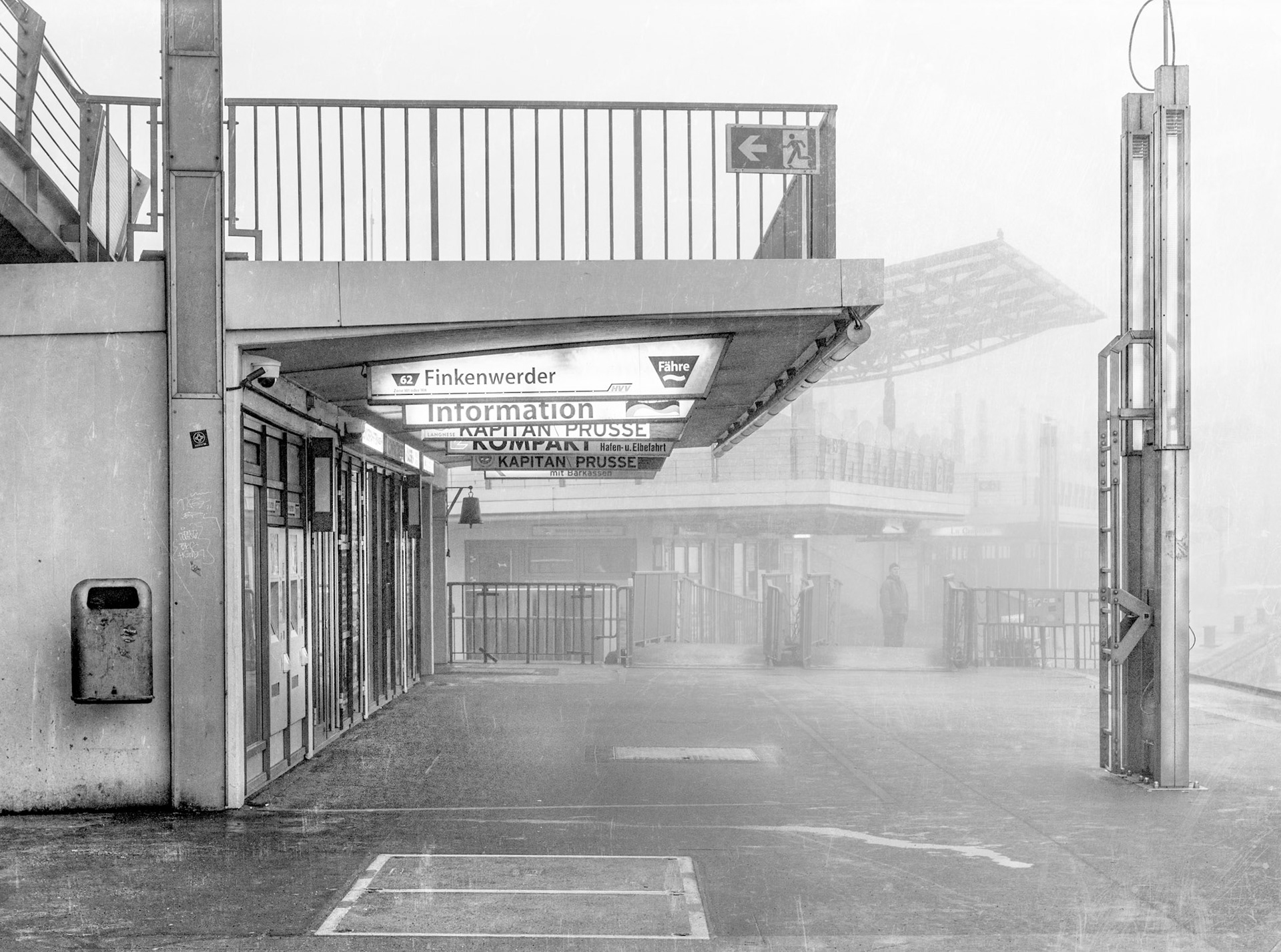 A dock worker wauting for the ferry at hamburg harbour in a foggy morning.