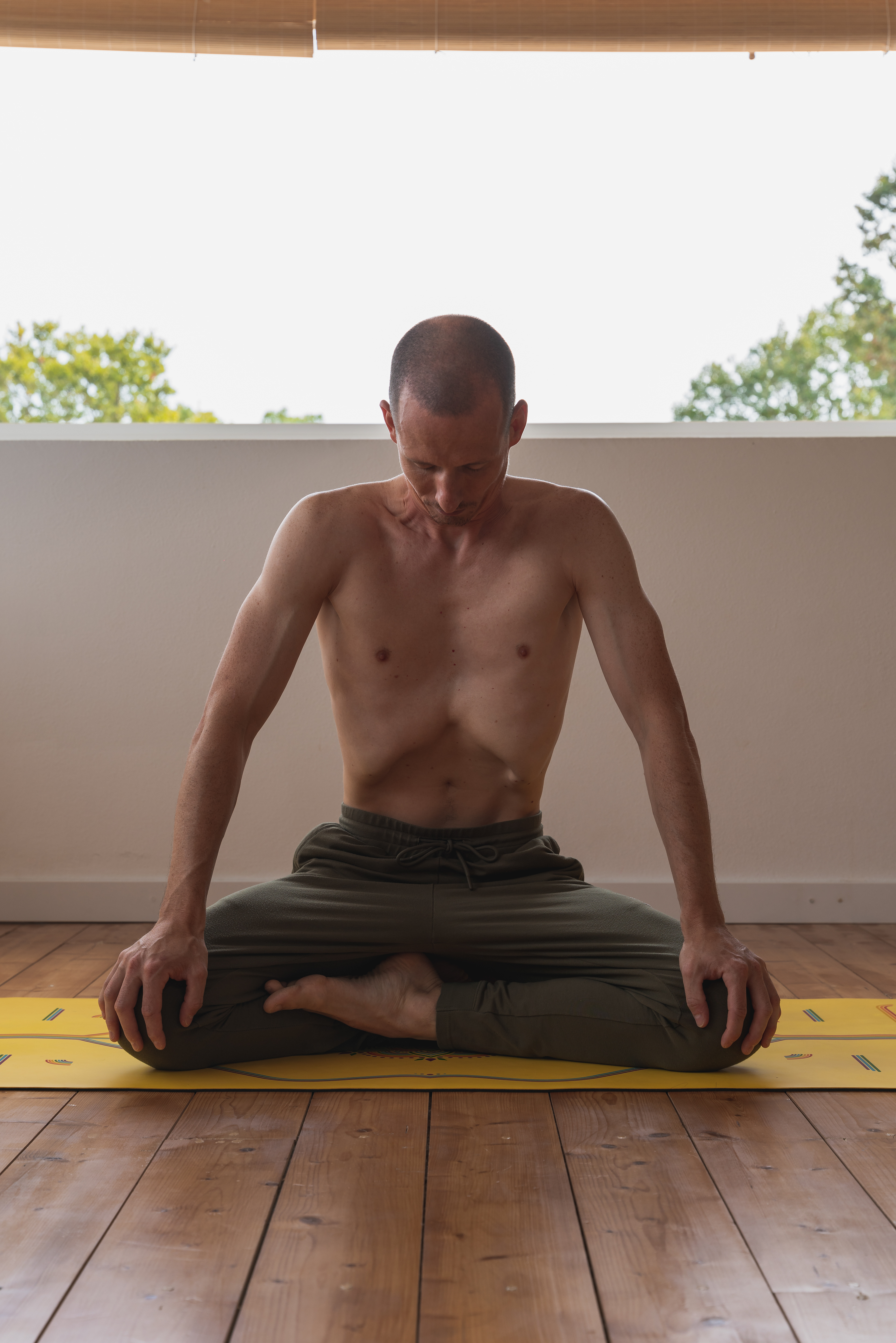 Patrick sitting in cross legged position practicing udijana bandha