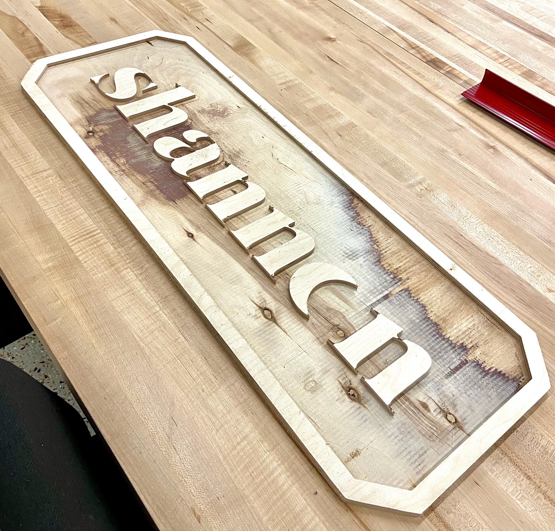 a multi dimensional wooden sign with a border along the outside and in the center is "shannon" in a serif font. the wood grains are visable.