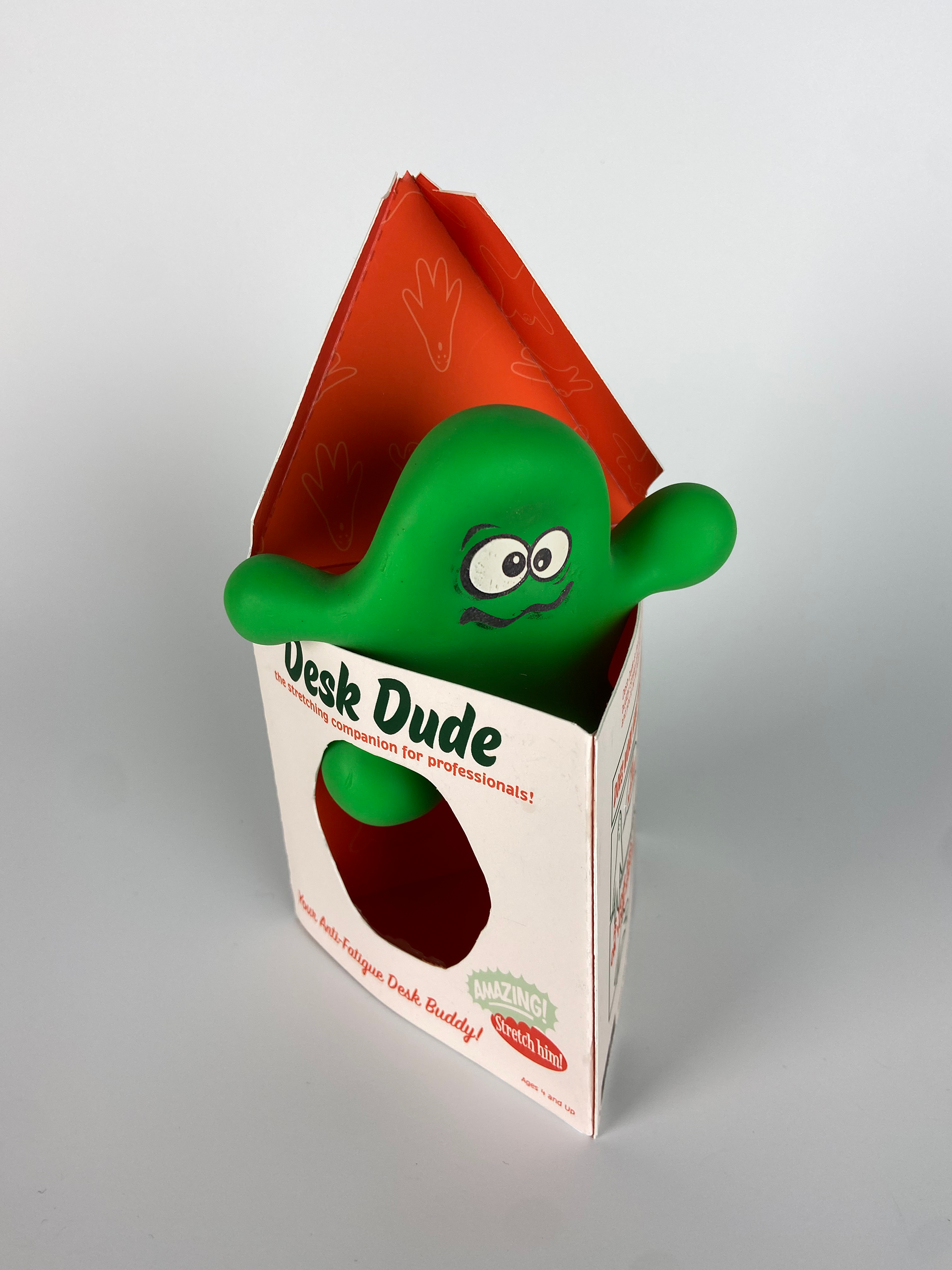 a side view of the triangular packaging. the green blob toy pokes out of the top.