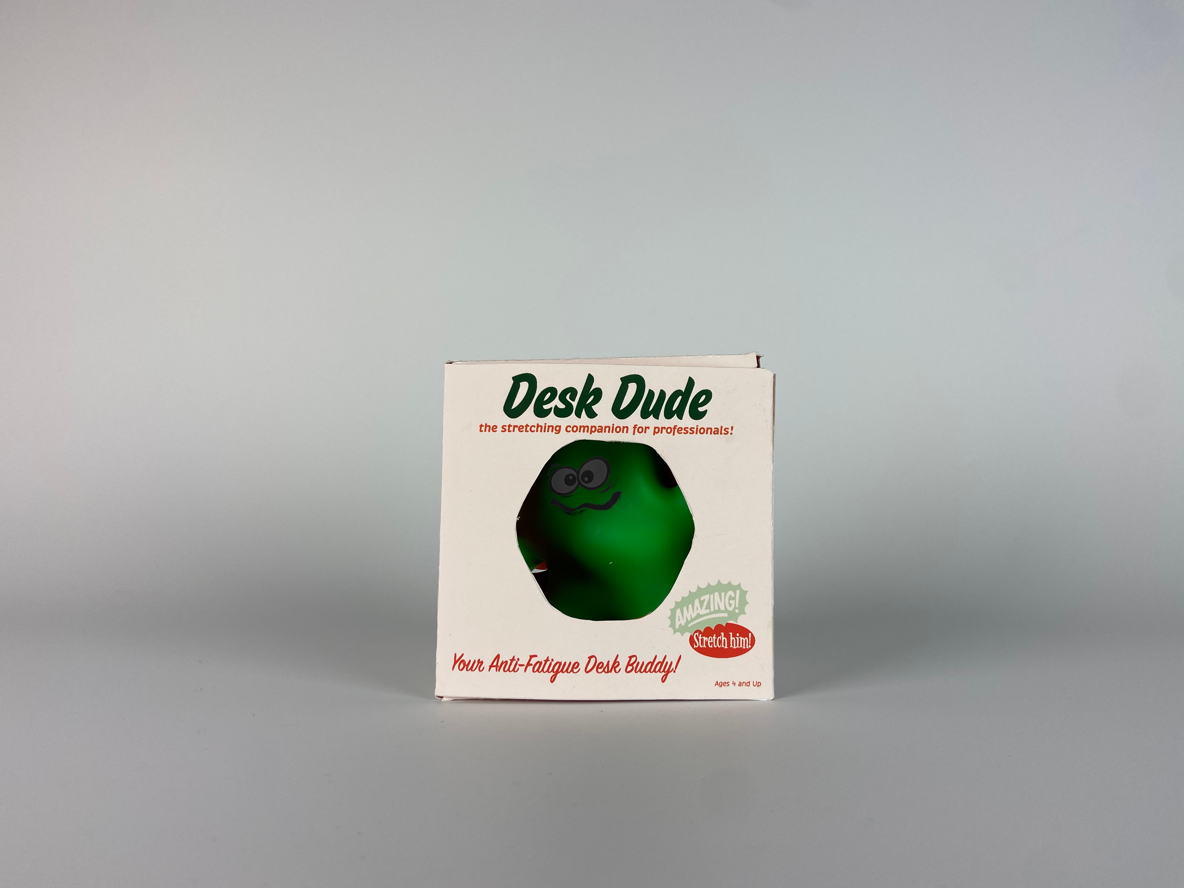 a green blob creature can be seen from the center window of its package