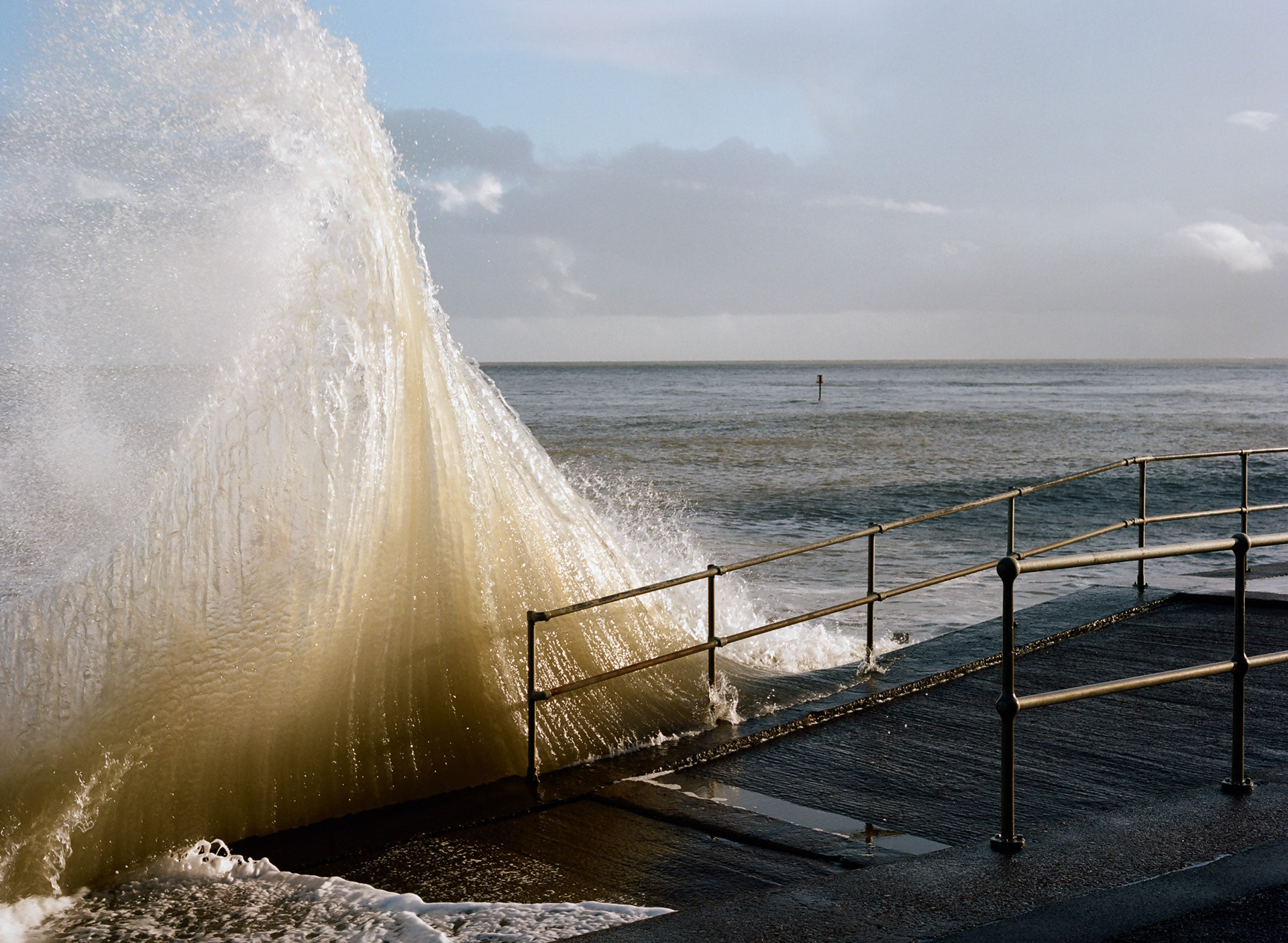 A huge wave crashes against the sea wall at Shanklin, Isle of Wight. A medium format photograph taken by Bristol based photographer Jake Hitchcock.