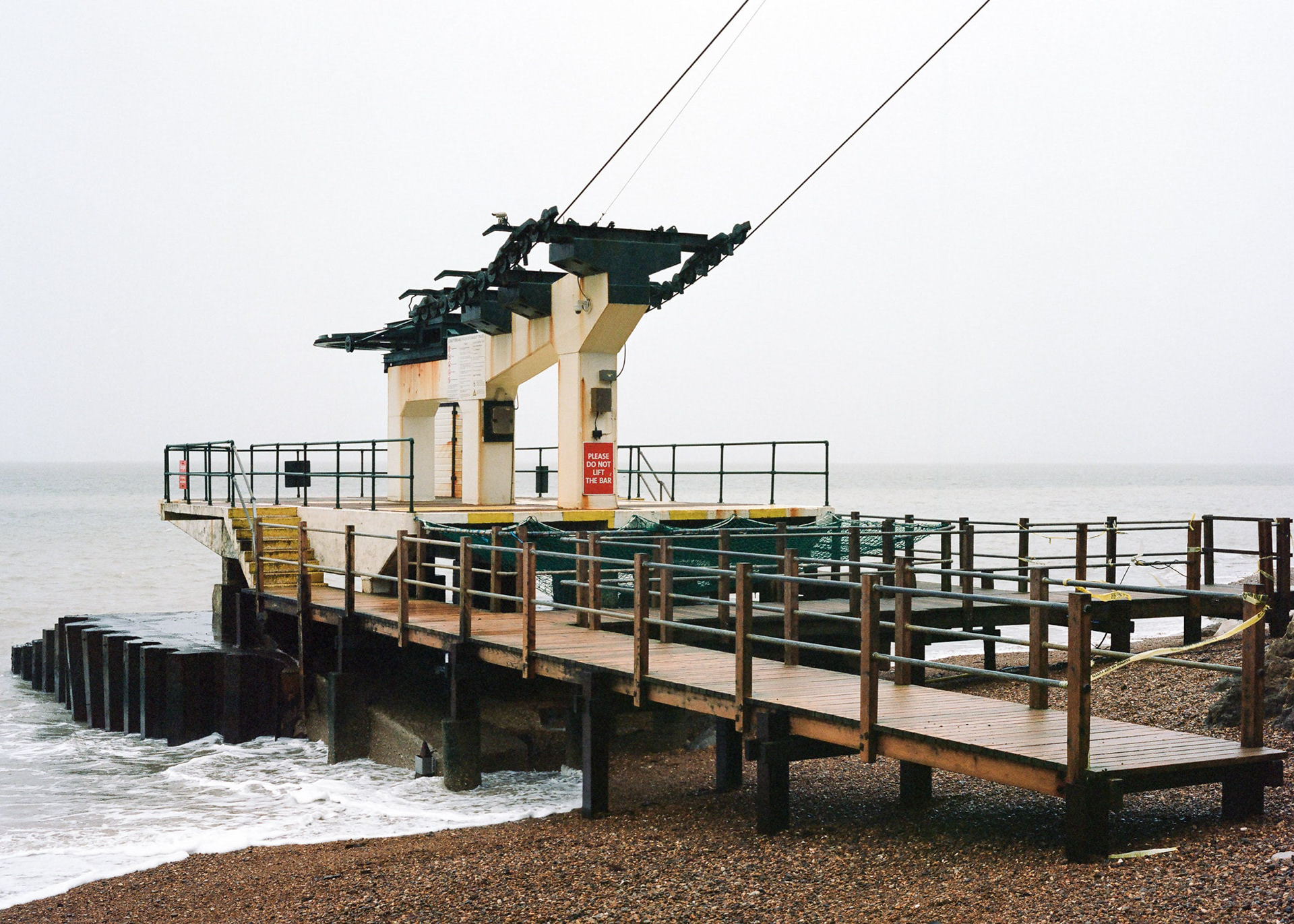 Alum Bay, Isle of Wight. The bottom of the chair lift doesn't look so safe in Winter. Rust and decay are evident. A medium format photograph taken by Bristol based photographer Jake Hitchcock.