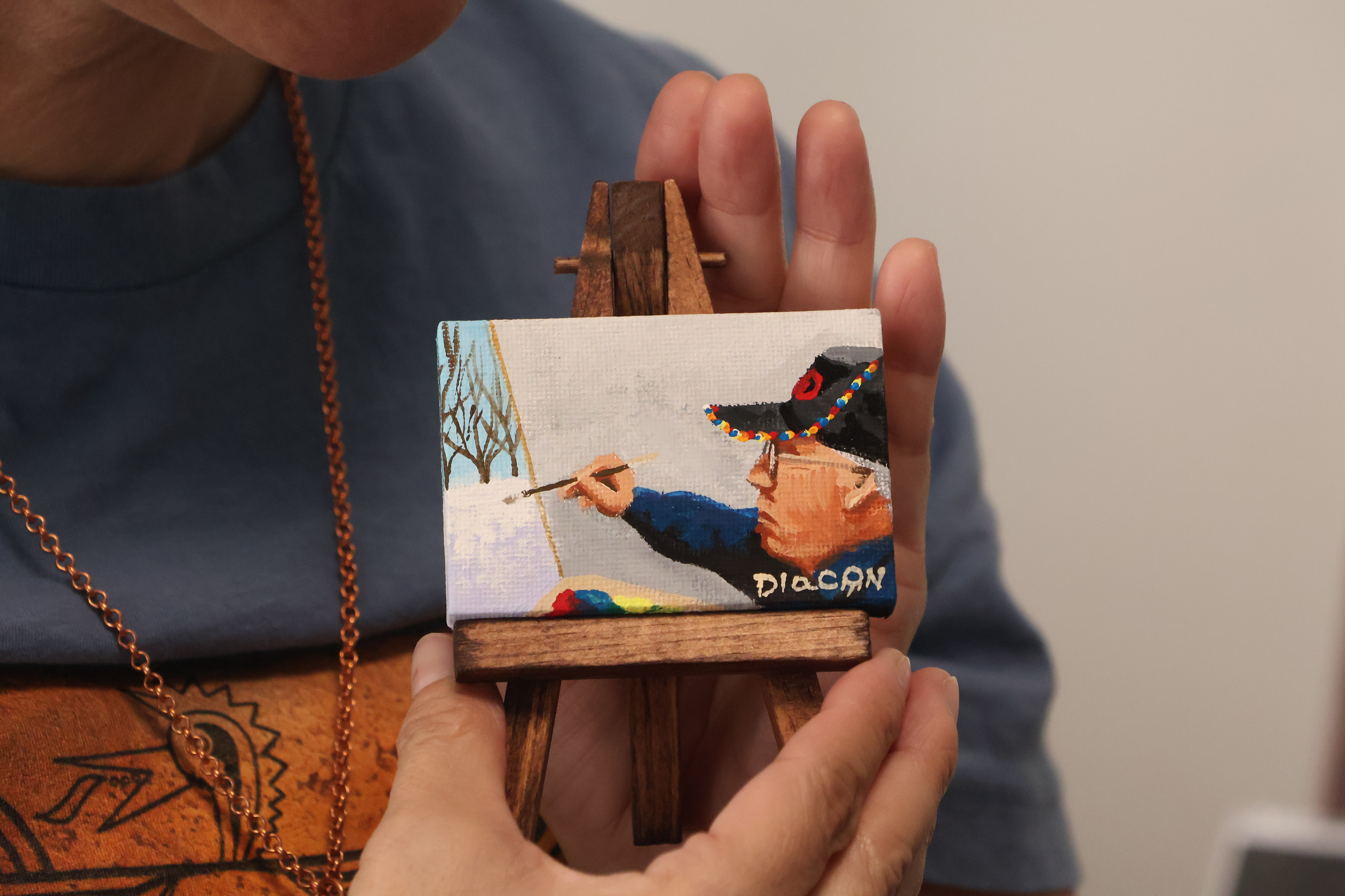 Dr. Stacy Pratt holding a self-portrait painted by Johnnie Diacon. Diacon was painting a "Trail of Tears" painting for the Native American History Museum in Arkansas. Elena Andra Stoica