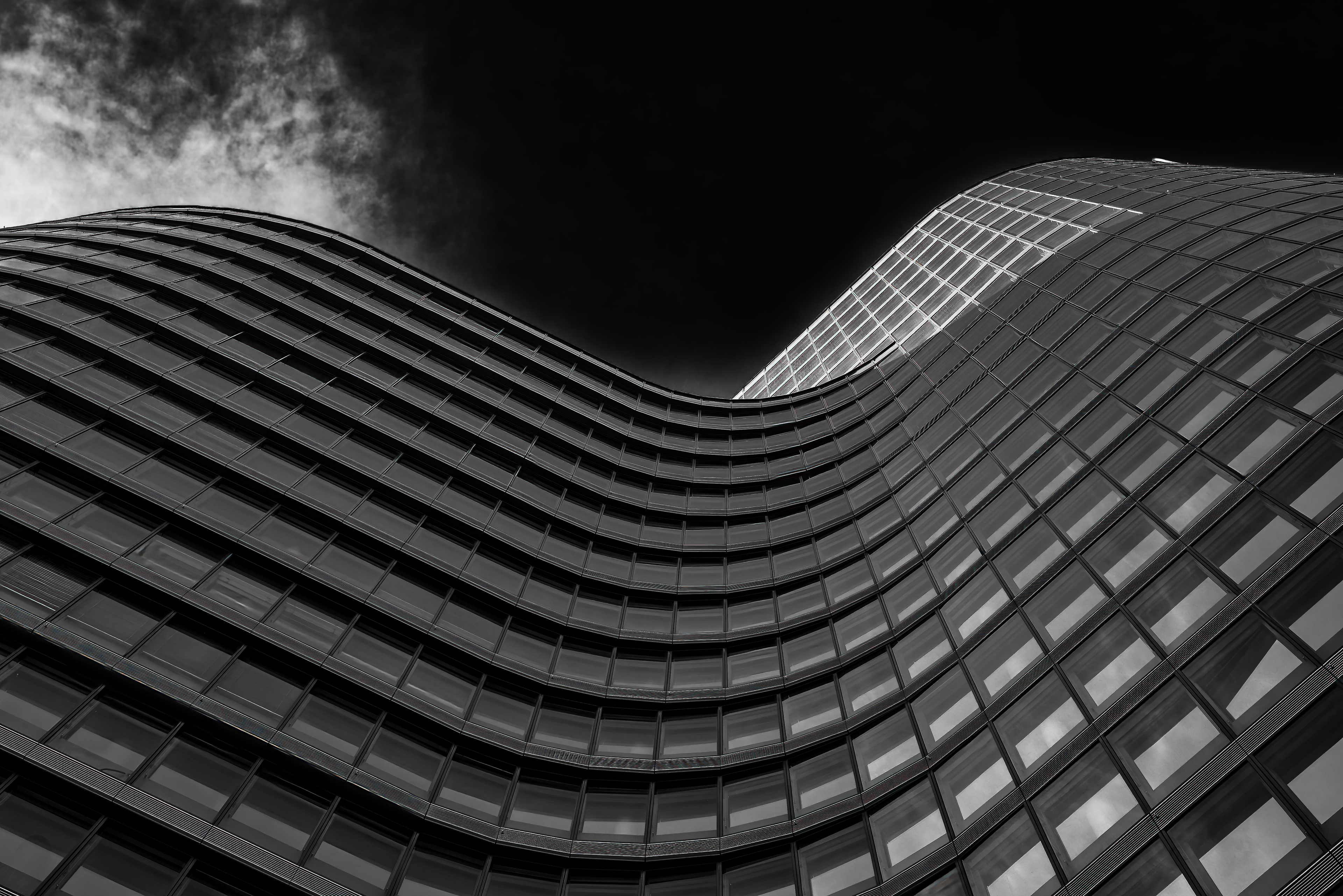 Modern office building with curved glass facade in black and white
