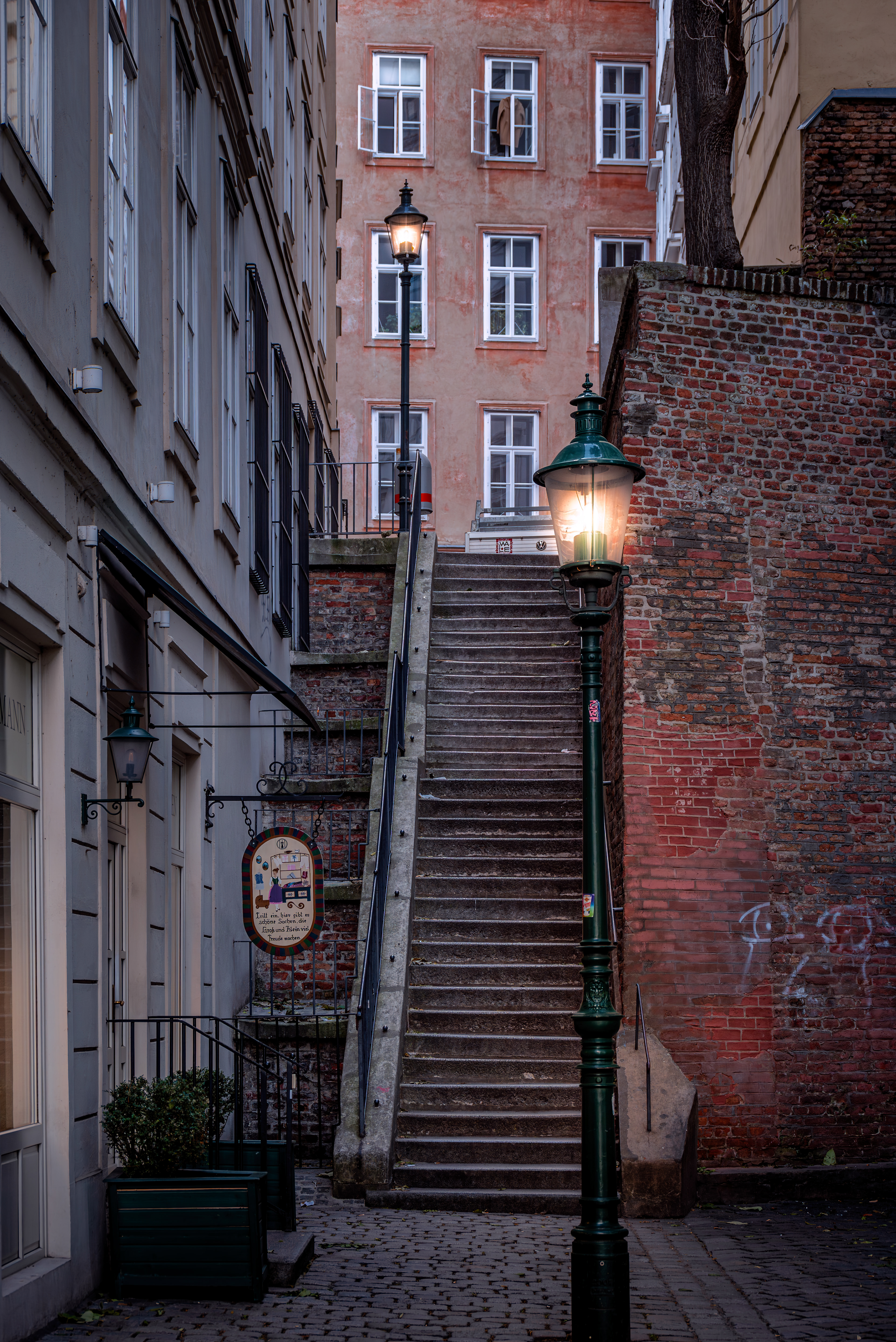 Narrow alley with staircase and street lamps