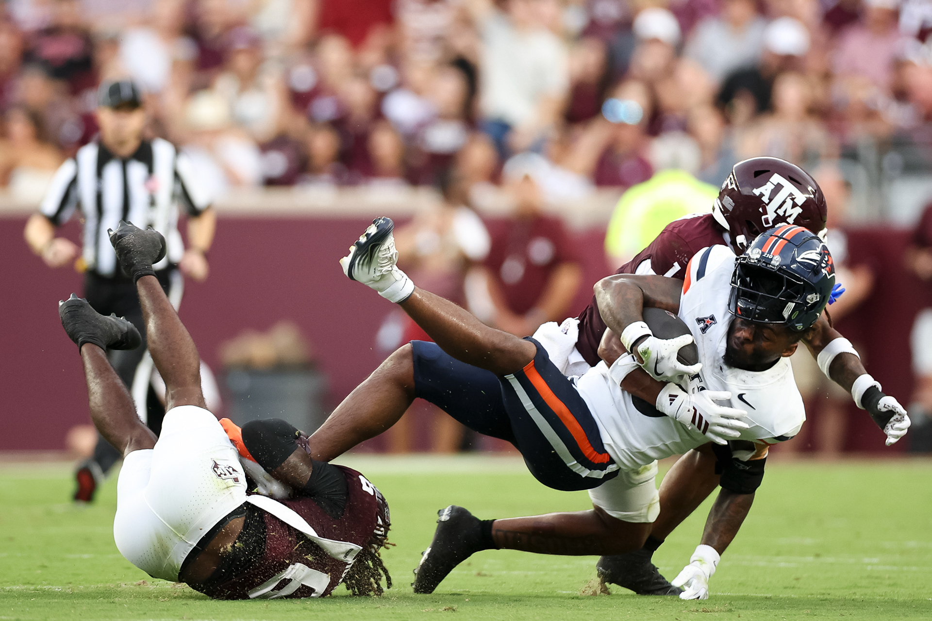 Texas A&M players CB Julio Humphrey (6) and DB Bryce Anderson (1) tackle UTSA RB Robert Henry Jr. (3) during the game against the Roadrunners at Kyle Field in College Station, Texas on August 30, 2025.