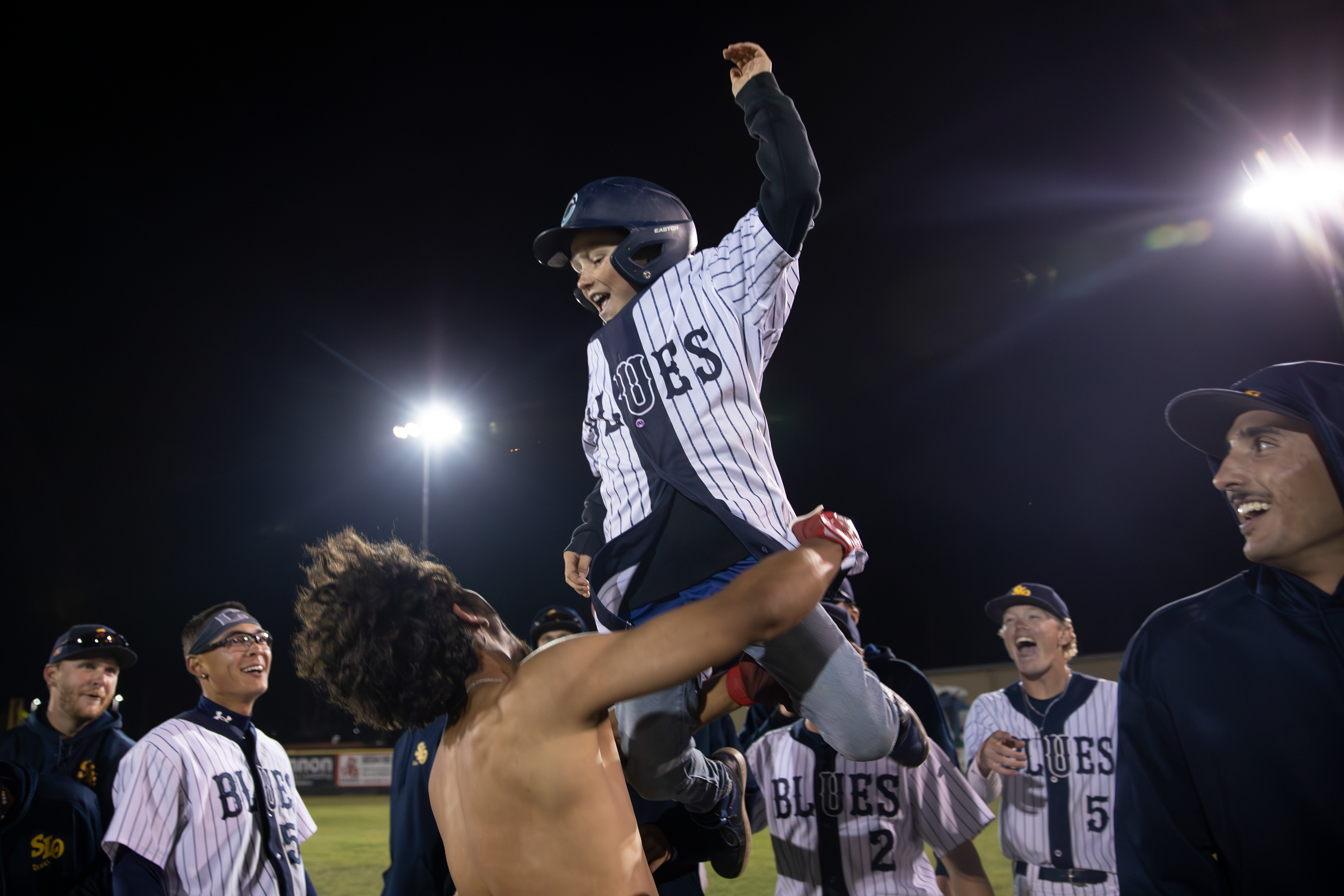 SLO Blues 2B Diego Murillo (7) throws the bat kid in the air following his walk-off hit during the game against the Arroyo Seco Saints at Sinsheimer Stadium in San Luis Obispo, California, on June 1, 2025.