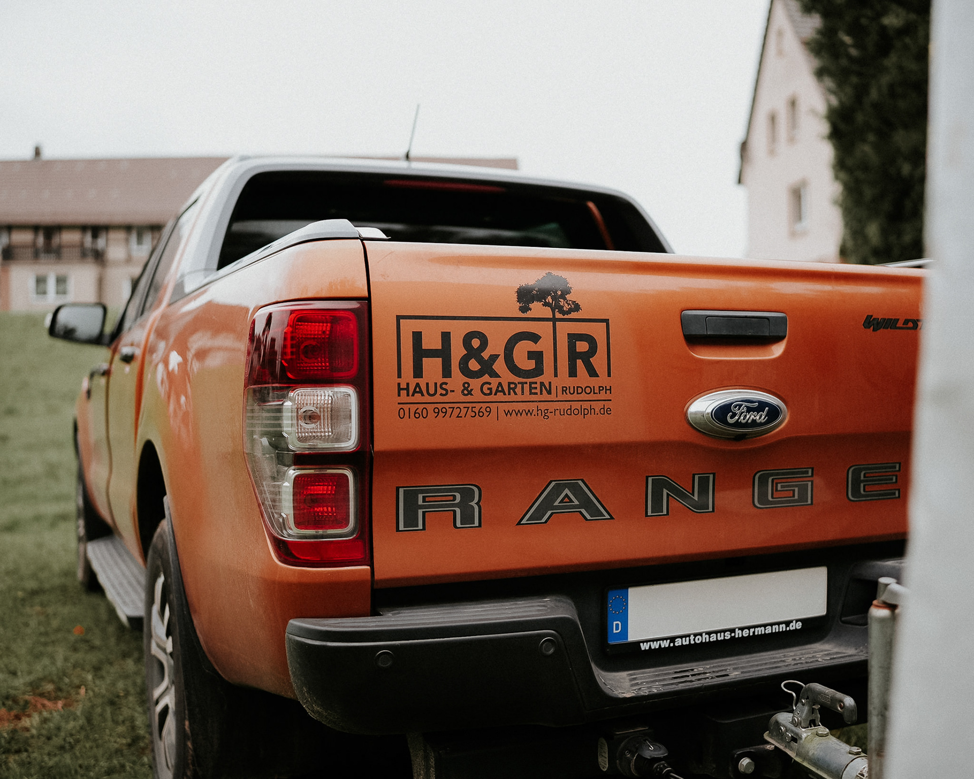 Ford Ranger mit Anhänger, beladen mit Gartenabfällen, bereit für den Abtransport nach einer Entrümpelung oder Gartenarbeit.