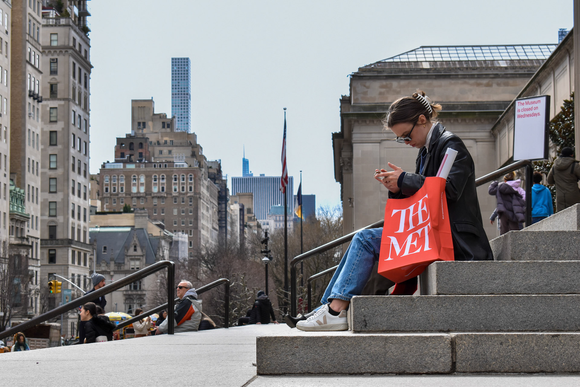 Lady At The Met 2: A woman at the Met checks her phone.