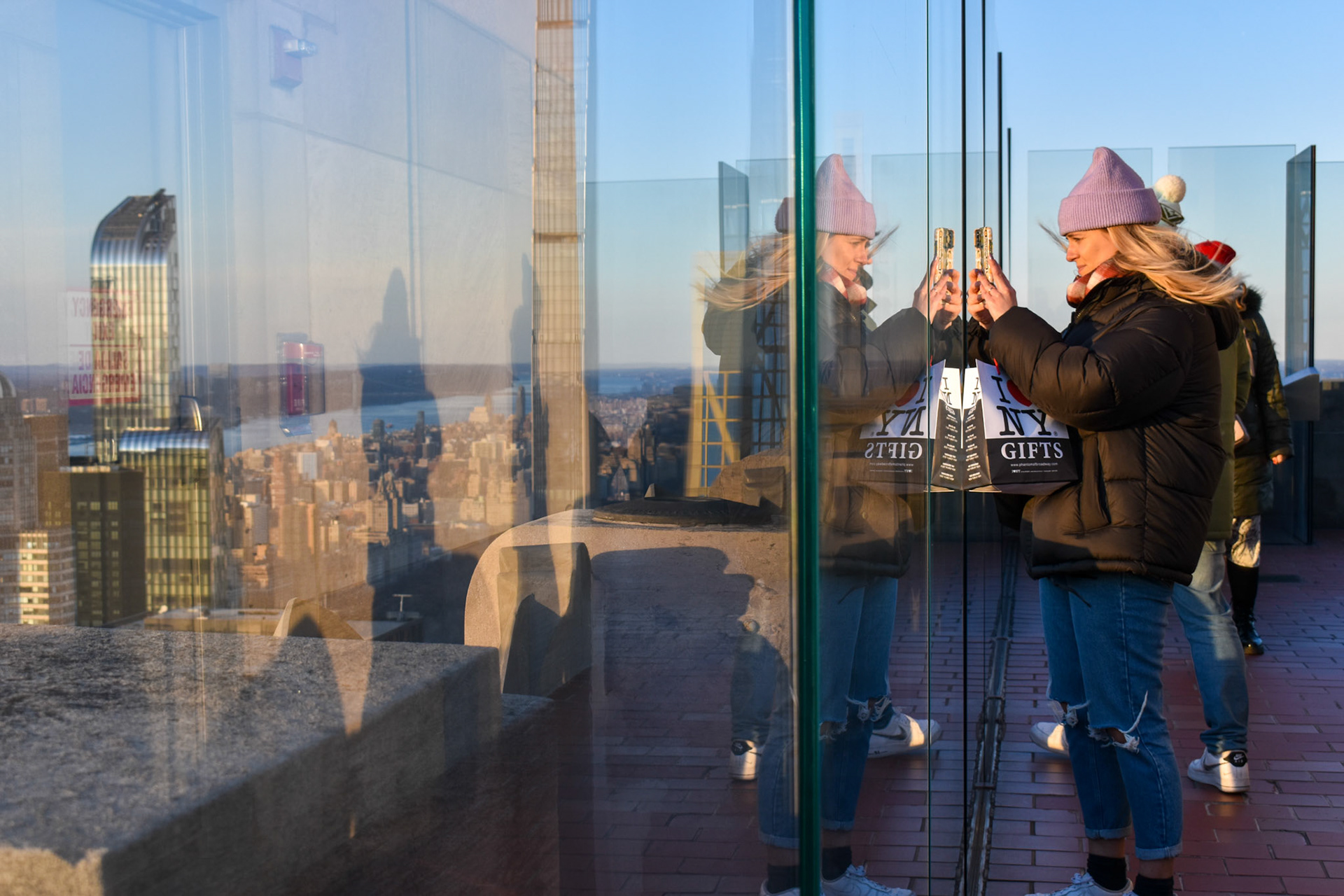 Tourism: A woman photographs New York City from the top of the Rockefeller building.
