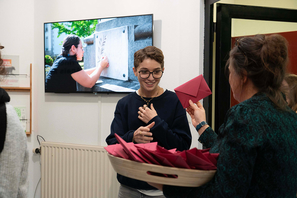 " Graines de mémoire " - 100 enveloppes sérigraphiées chacune avec 2 graines de roses trémières - distribution pendant vernissage auprès du public et exemplaires exposés en trace de cette action lors de l'exposition - vue de l'exposition "L'enracinement - Chapitre 1 : J'ai mille et une raison de vous dire cela " - Rurart 10.10 au 12.12. 2024 - Photo : Victor Bonnarme