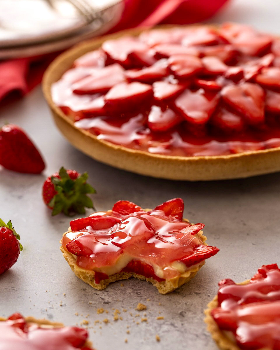 Sweet tarts with a custard and strawberry filling with the light reflecting off their tops by Anusha Stewart Media
