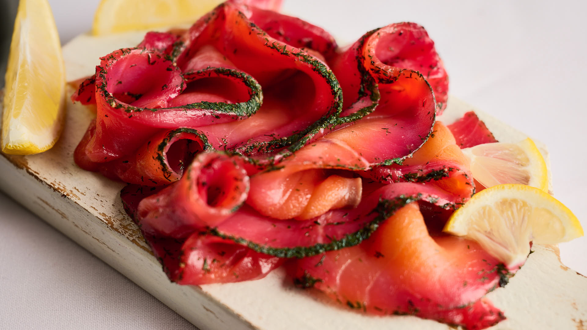 Beetroot Cured Smoked salmon on a white chopping board