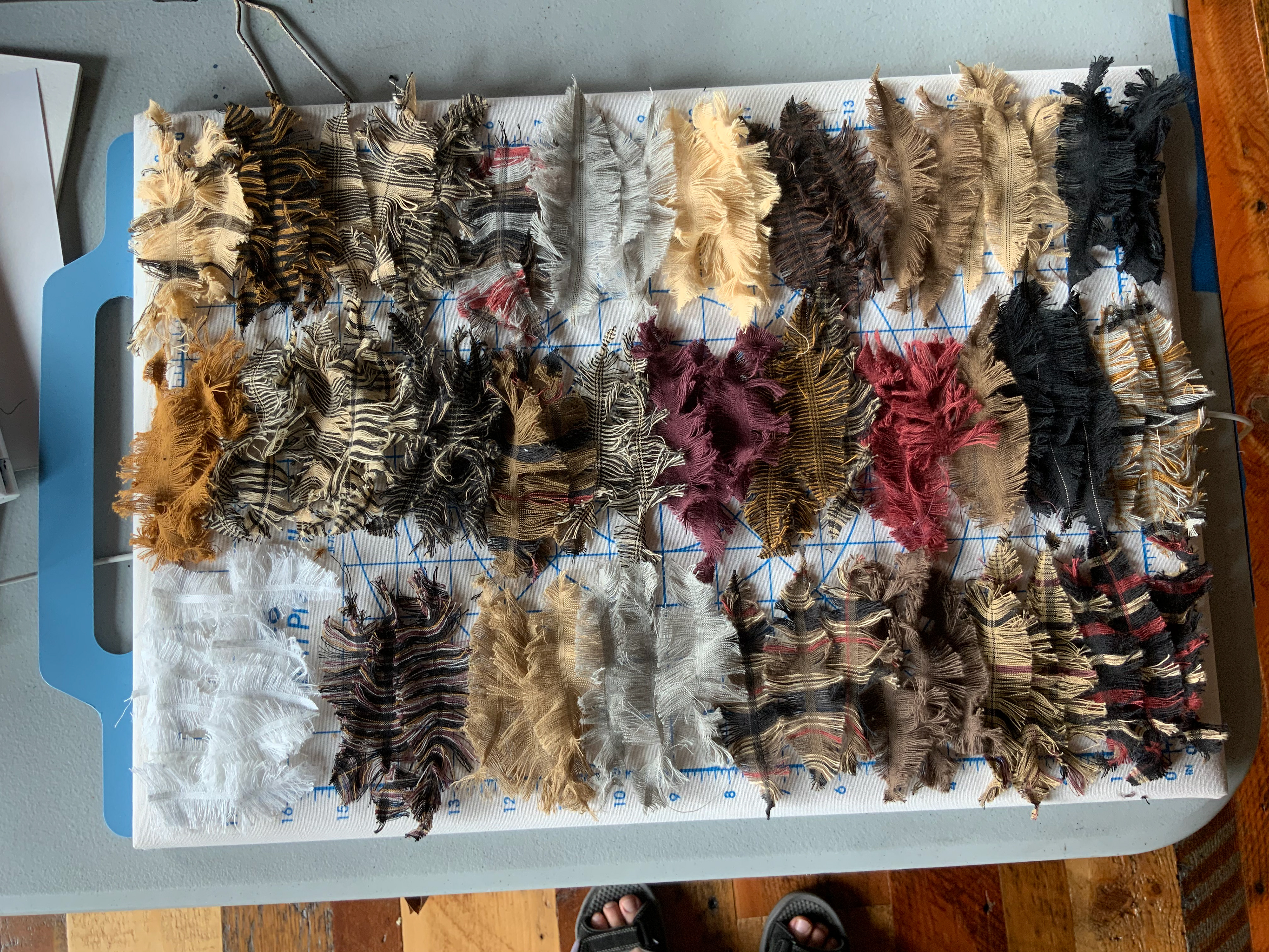 Hand pulled vertical threads from fabric to create feathers.