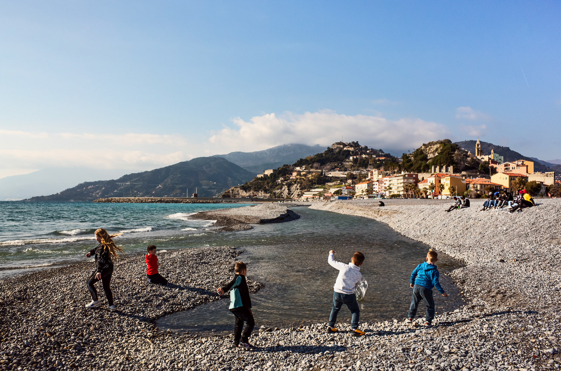 The Roya River originates in French territory, at the Col de Tende, and flows into Italy at Ventimiglia. The river mouth is a place frequently visited not only by tourists and families but also by migrants. From here, France is clearly visible.