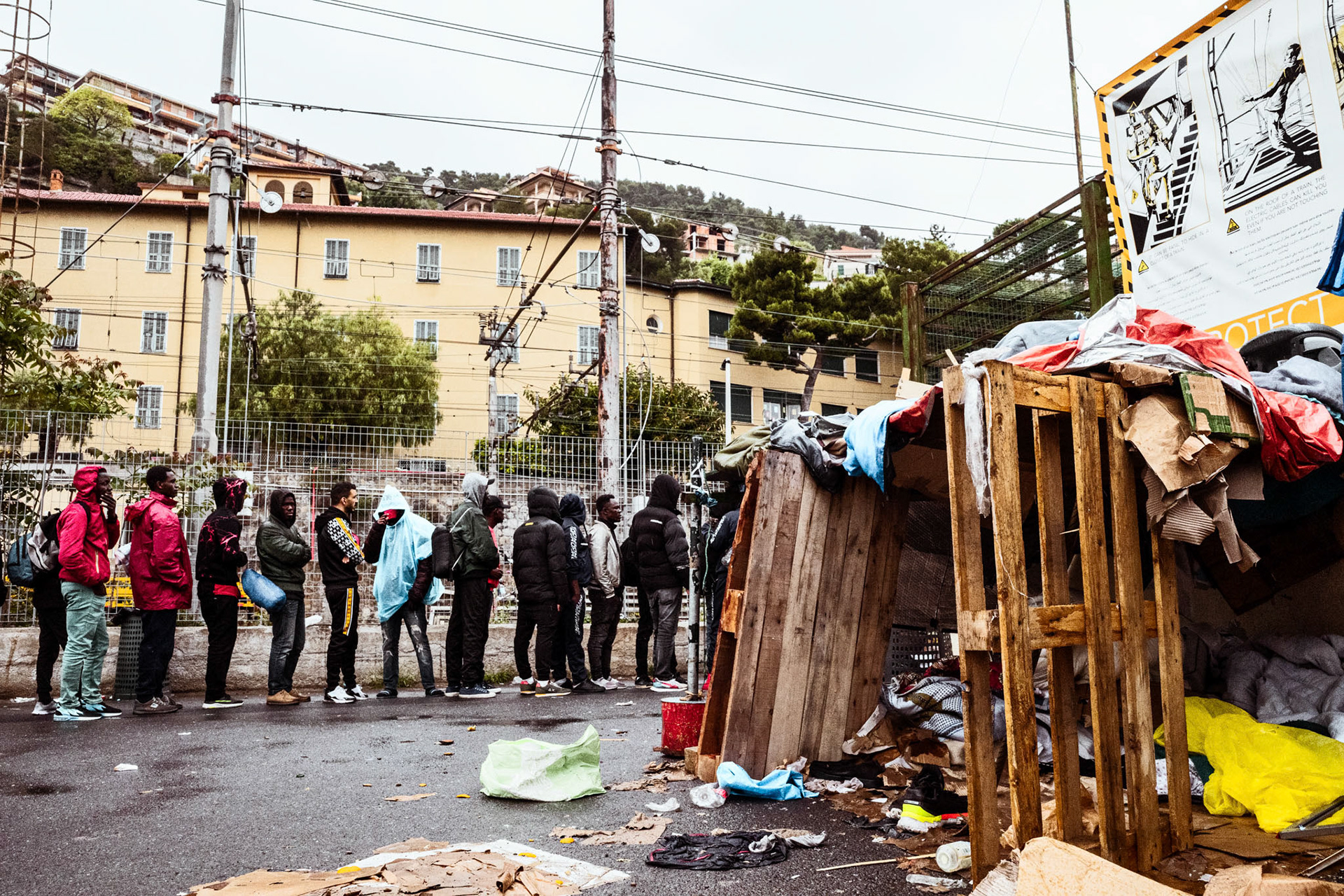 The queue for the canteen meal distribution. On the right, a shack built by some young men from Guinea in transit.