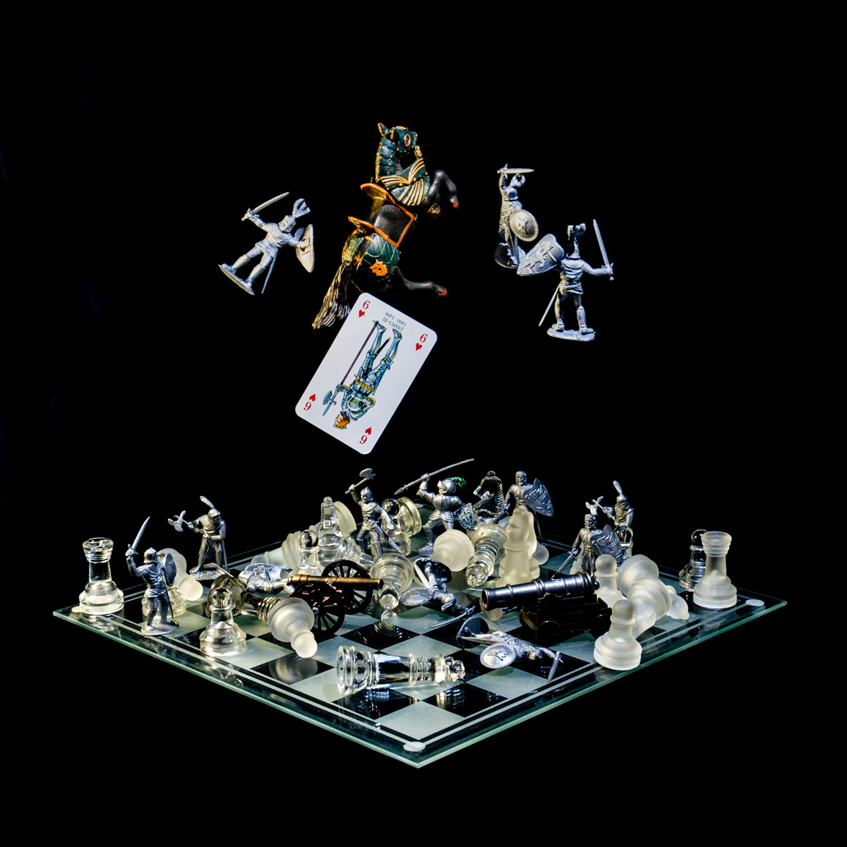 Photographic art that tells the story of a battle against a group of rebellious nobles resulting in the death of King James III, using a chessboard, playing card and objects.