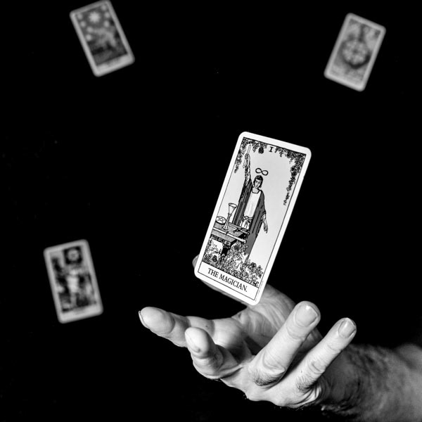 Black and White fine art photography image of a hand with a magician playing card floating above/