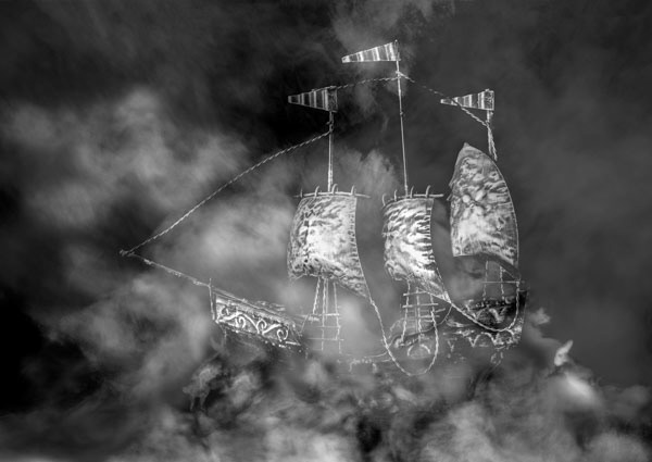 A monochrome photograph depicting ethereal smoke-like figures in the shape of hares and a ship, representing King James belief in witchcraft and supernatural.