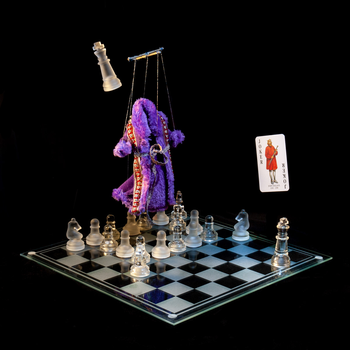 Photographic art that tells the story of John Balliol who was installed as a puppet king by the English monarch, using a chessboard, playing card and objects.