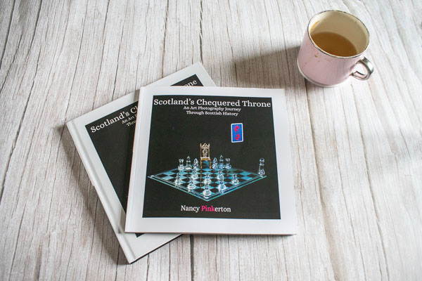 photo of Scotland's chequered throne hardcover and paperback books next to a cup of coffee
