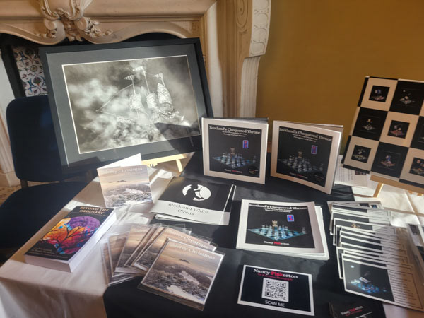 Image of books zines prints and postcards set up at a fair stall.