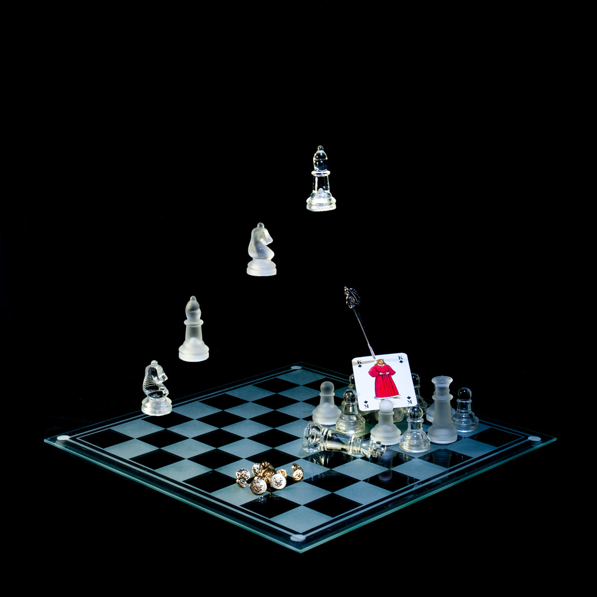 Photographic art that tells the story of the assassination of King James I by his own court, using a chessboard, playing card and objects.