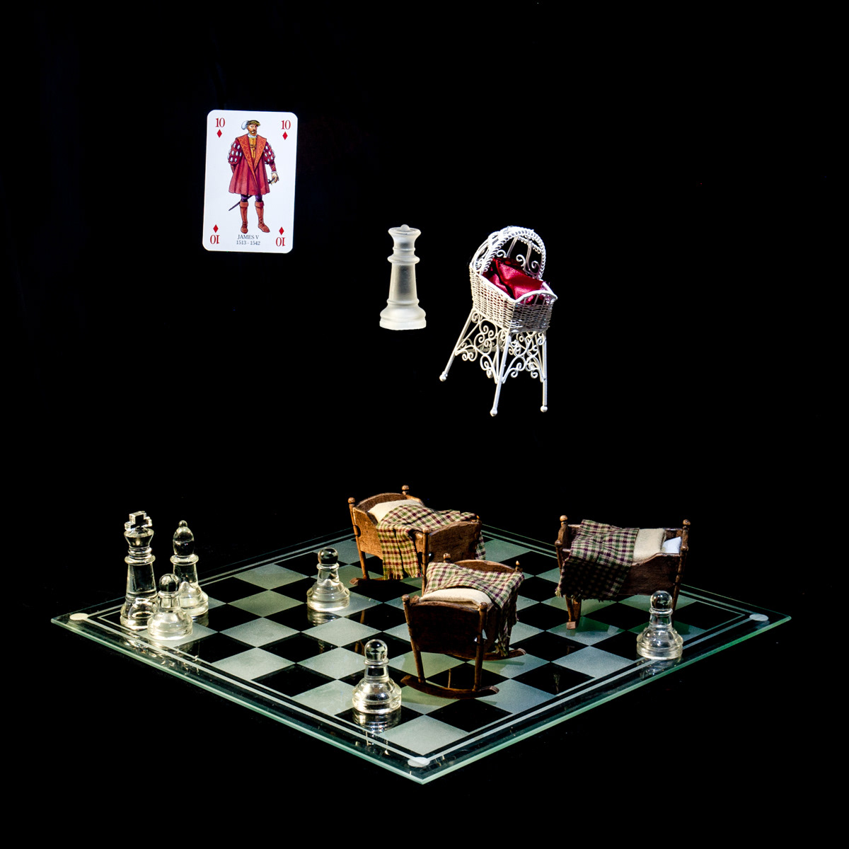 Photographic art that tells the story of King James V's numerous affairs resulting in more illegitimate children than successors, using a chessboard, playing card and objects.