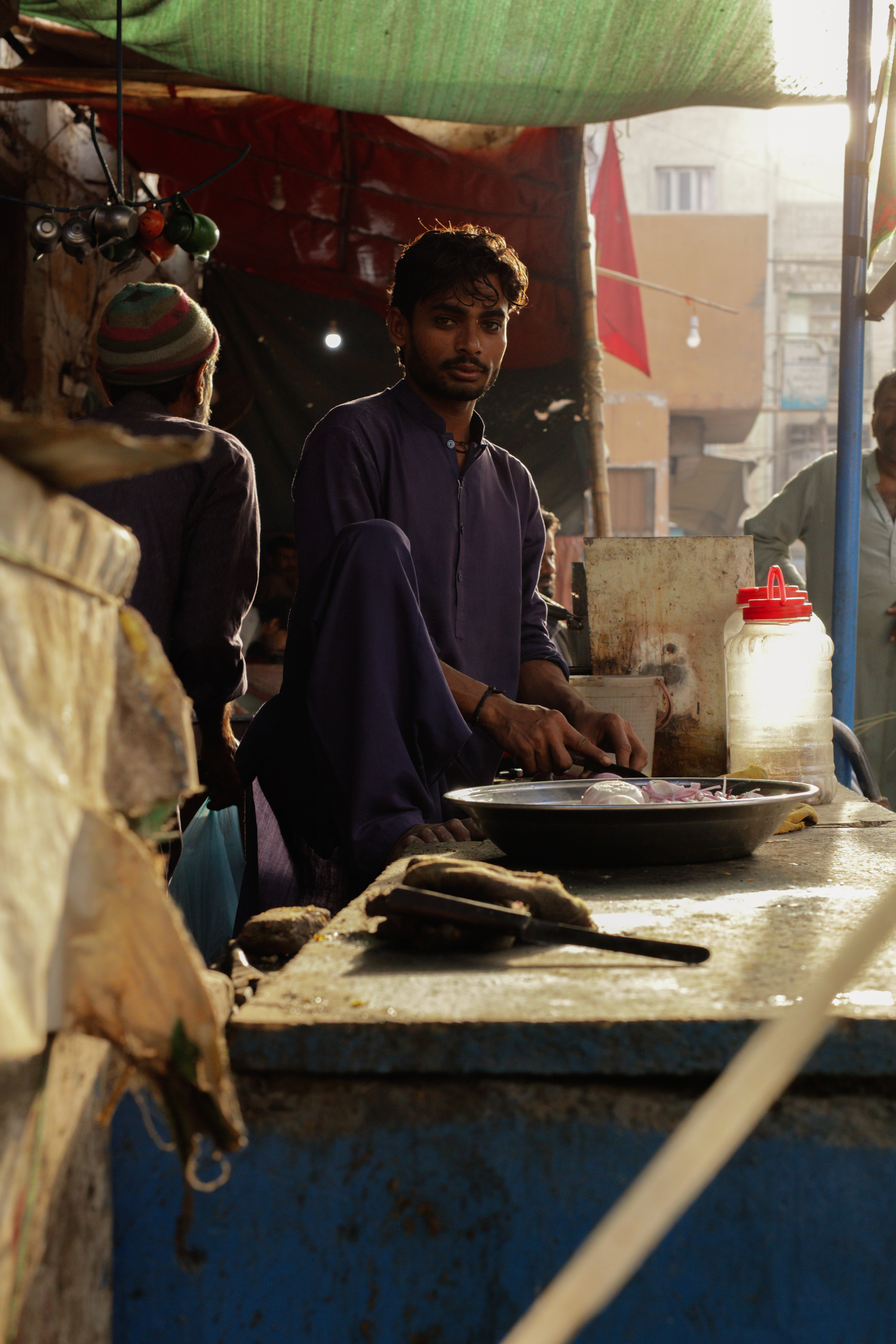 An employee in a food restaurant cuts onions early in the morning, in Lee Market, December 25th 2021.