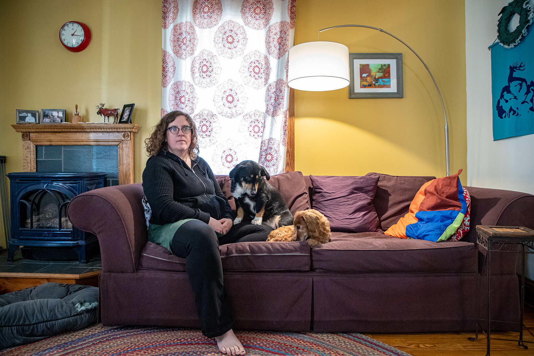 Childbirth worker Kate Dimpfl sits on the couch with her dogs Wednesday, Feb. 21, 2024 at 304 East Lincoln Street, Ithaca, NY. Ithaca is one of the cities that has the highest percentage of home birth rate, according to Dimpfl, who has been working as a birth worker in Ithaca, NY since 2010. Photo by Xinyi Qin.
