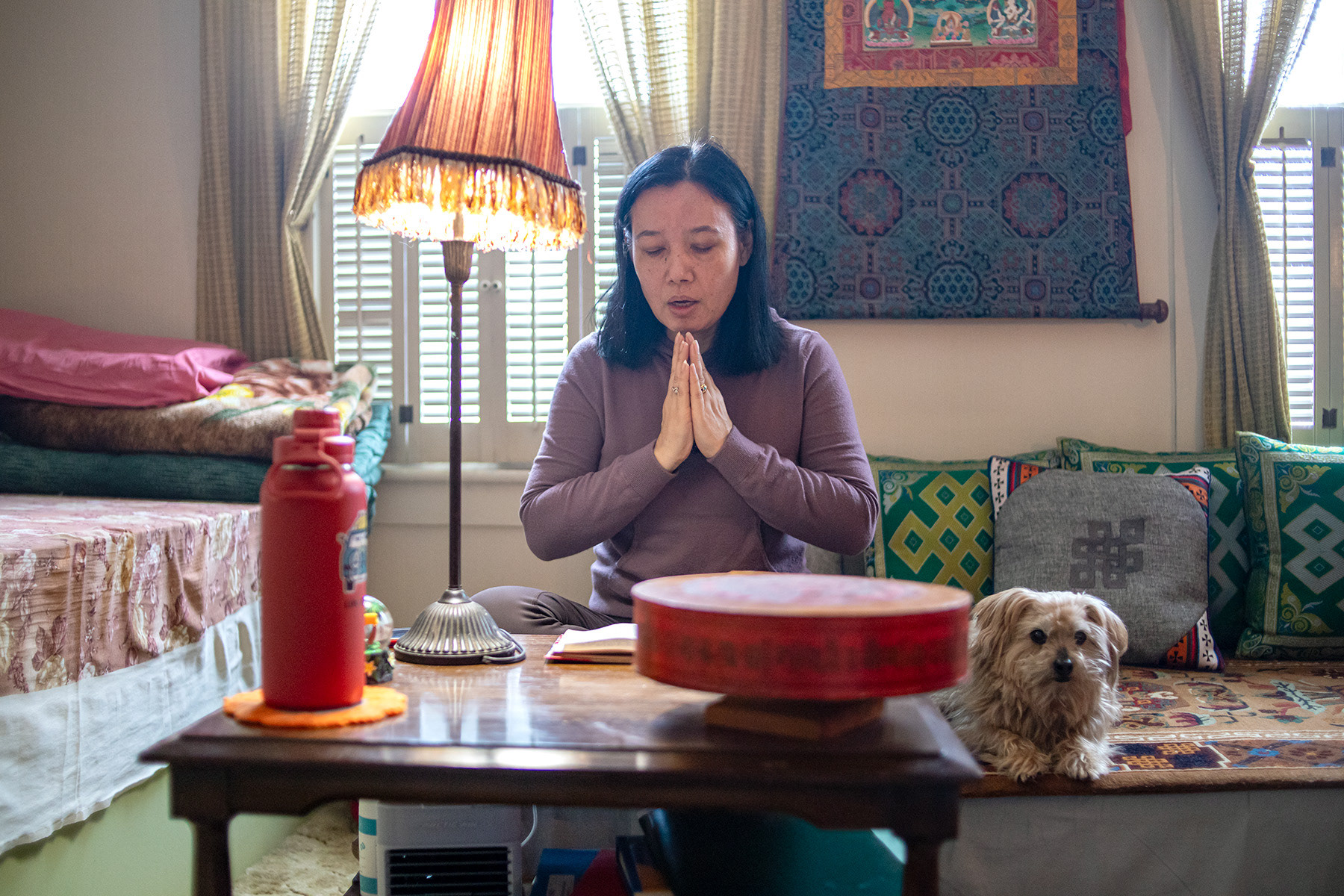 Tenzin Tsokyi, president of Tibetan associeation in Ithaca, prays in the morning Sunday Feb. 18, 2024 on Lincoln Street, Ithaca, NY. Tsokyi and her husband Nyima Dhondup are one of the 1,000 Tibetan families being supported by United States in 1992. Photo by Xinyi Qin.