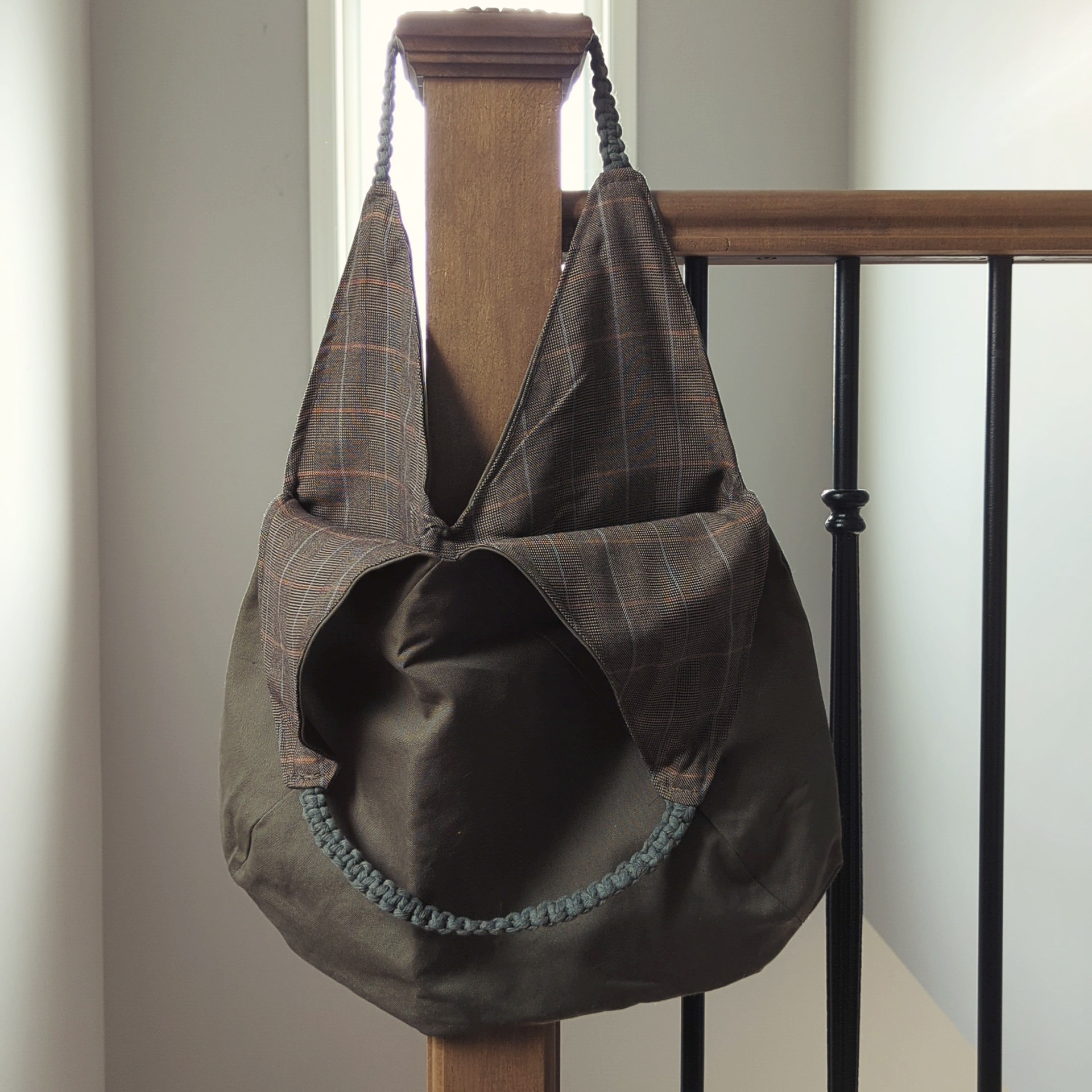 Army green bag with brown plaid interior and green macrame straps