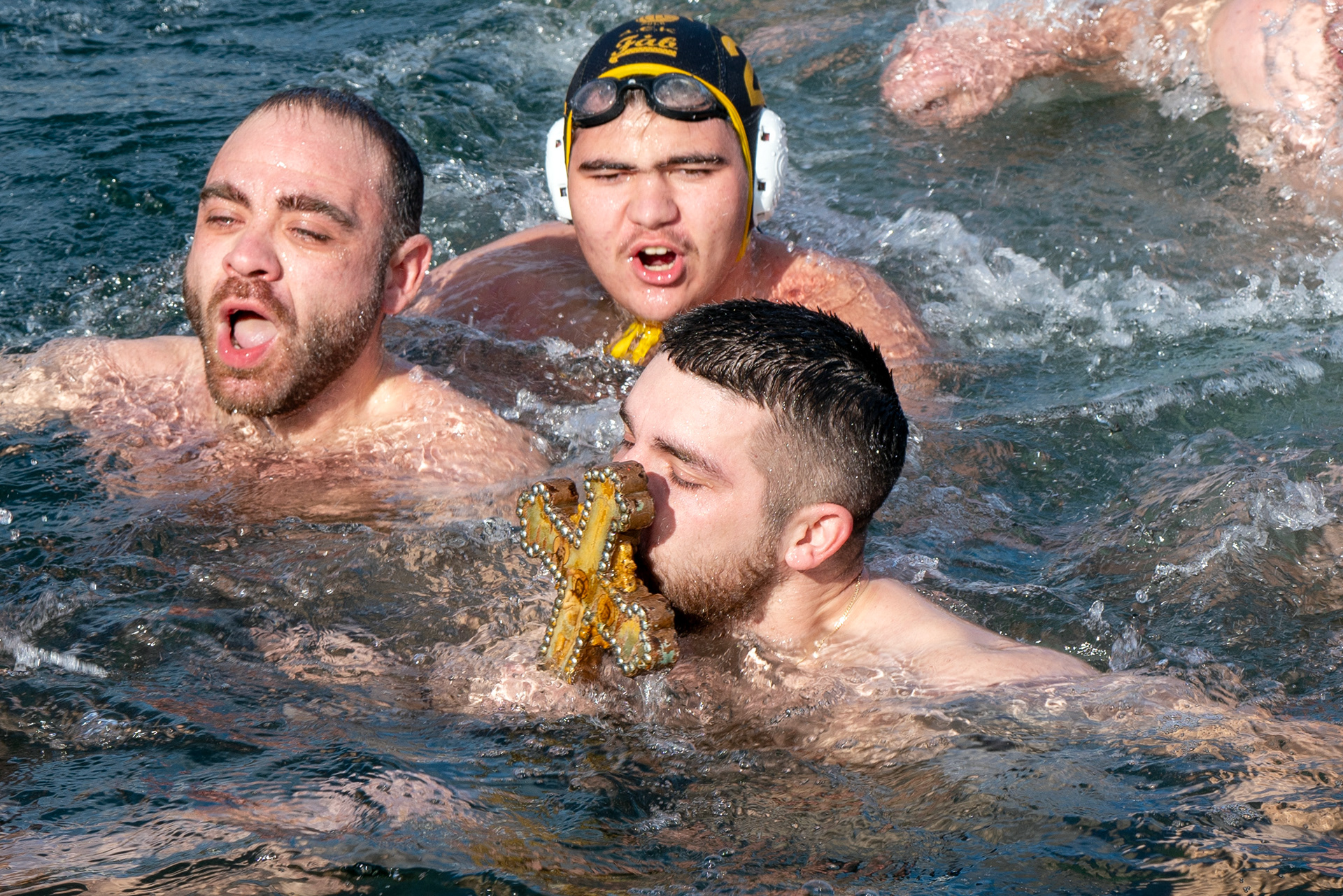 A Greek Orthodox swimmer kisses a wooden cross during the Epiphany Day ceremony on the shores of the Golden Horn in Istanbul, January 6, 2024. During the ritual, priests throw crosses into the sea to be catch the cross by swimmers.