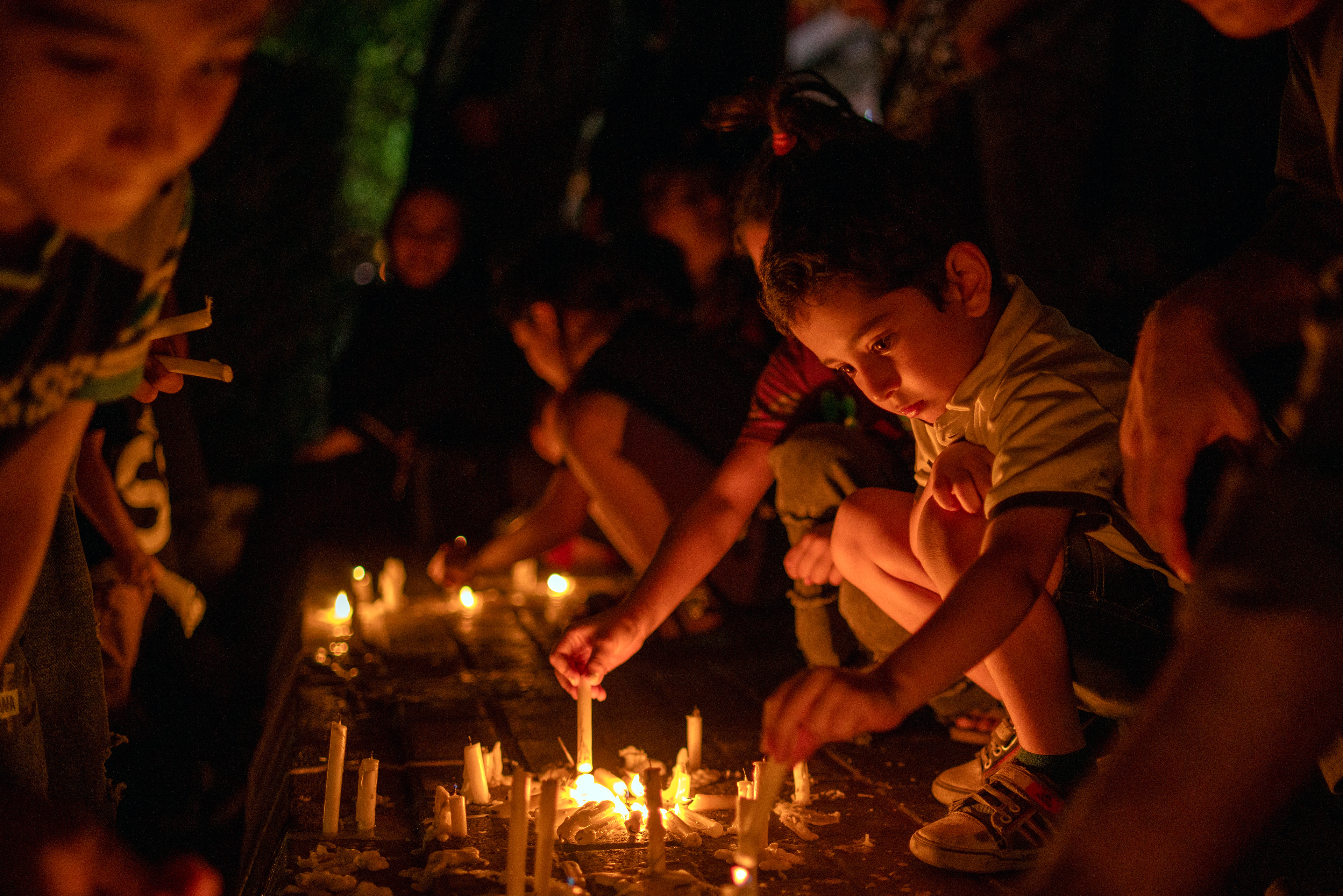 A child, in Tabriz, Iran on July 27, 2023, lights a candle to being a light for Imam Hussein on Tasua Day, the day before Ashura, the 1384th anniversary of Imam Hussein's martyrdom.