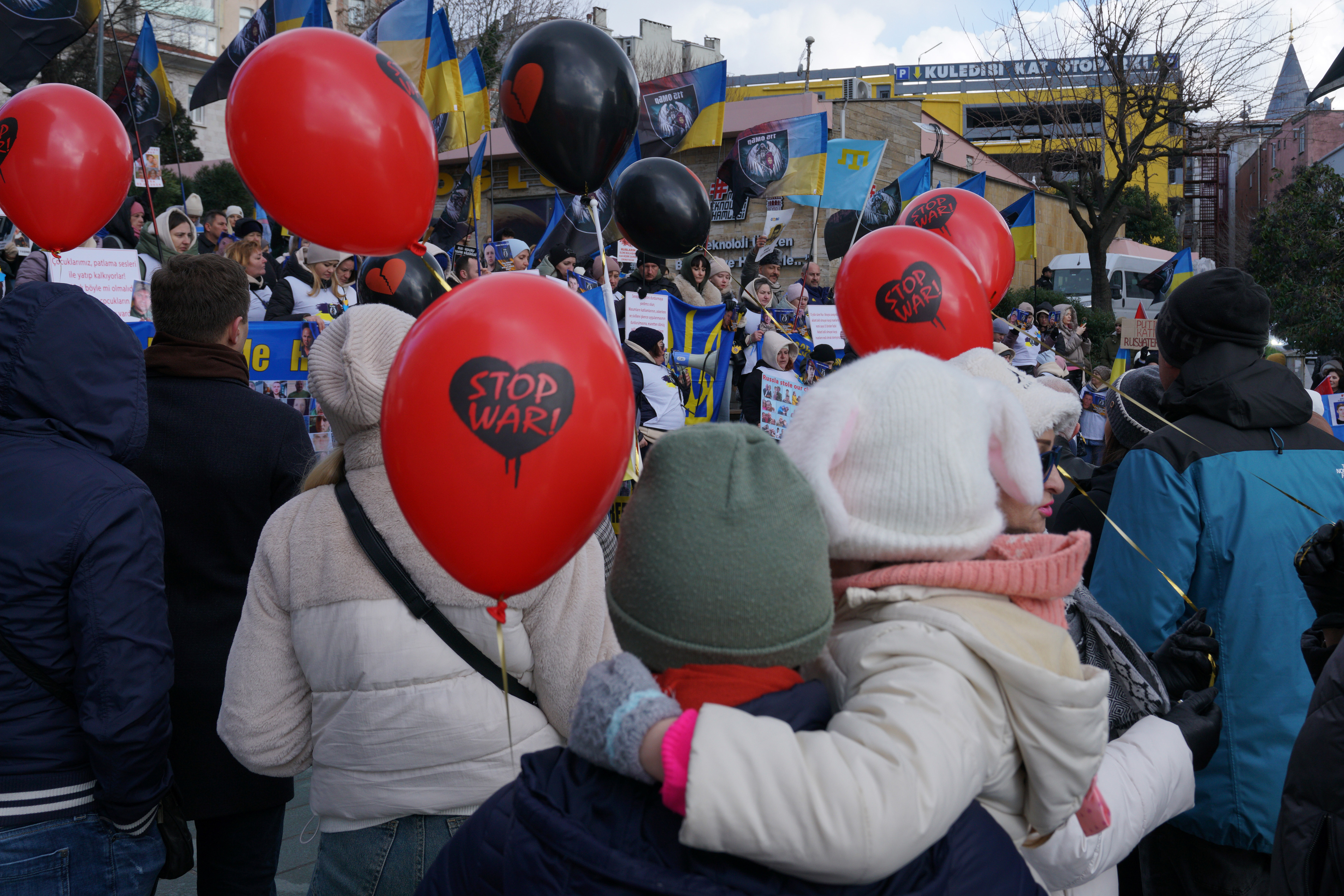 A child hold a balloon reading ''Stop War'' while hugging her mother as they attends a demonstration commemorating the third anniversary of Russia's invasion of Ukraine in Istanbul, Turkey on February 23, 2025.