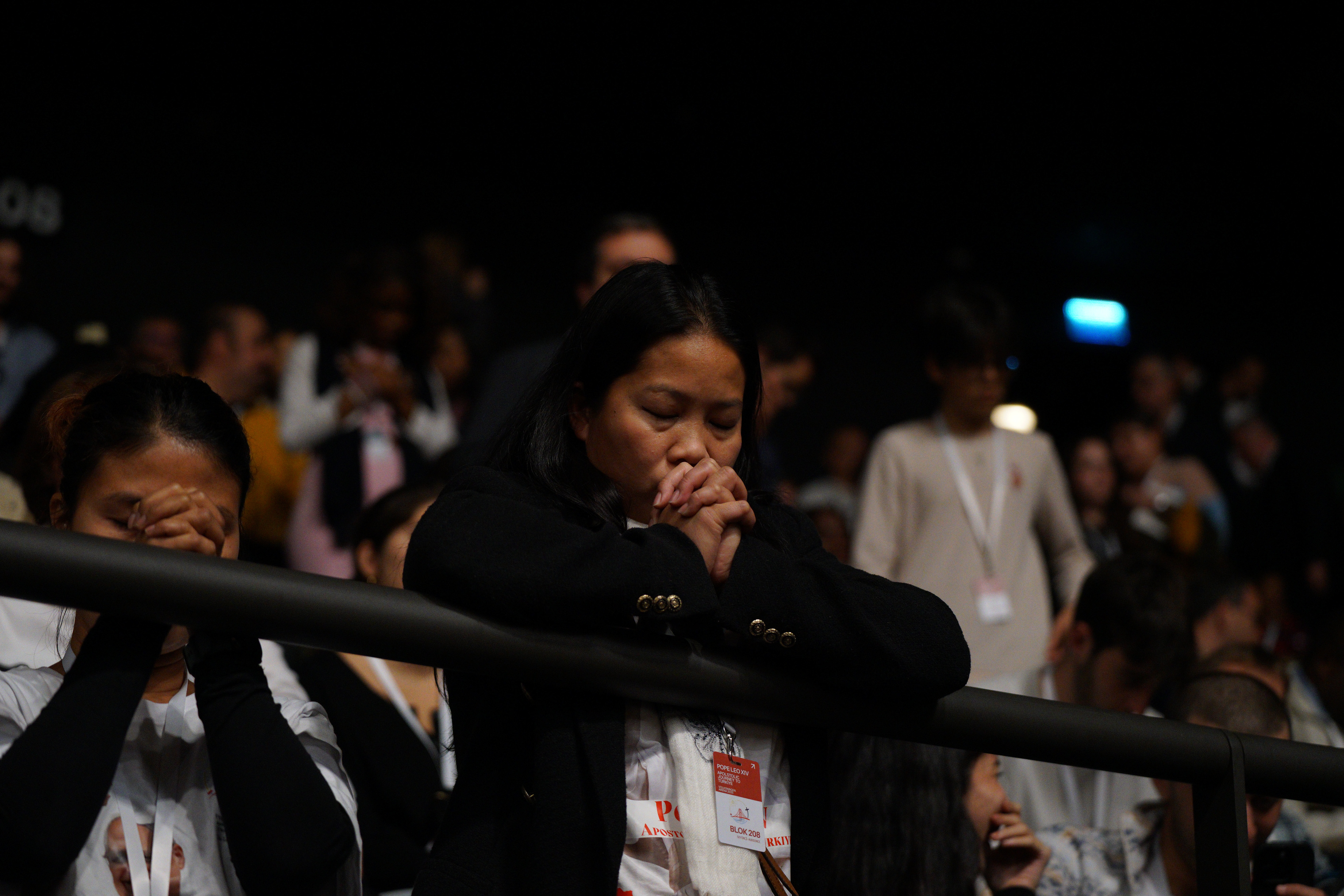 Faithfuls pray as Pope Leo XIV celebrates a Mass at the Volkswagen Arena in Istanbul, during his first apostolic journey, on November 29, 2025.