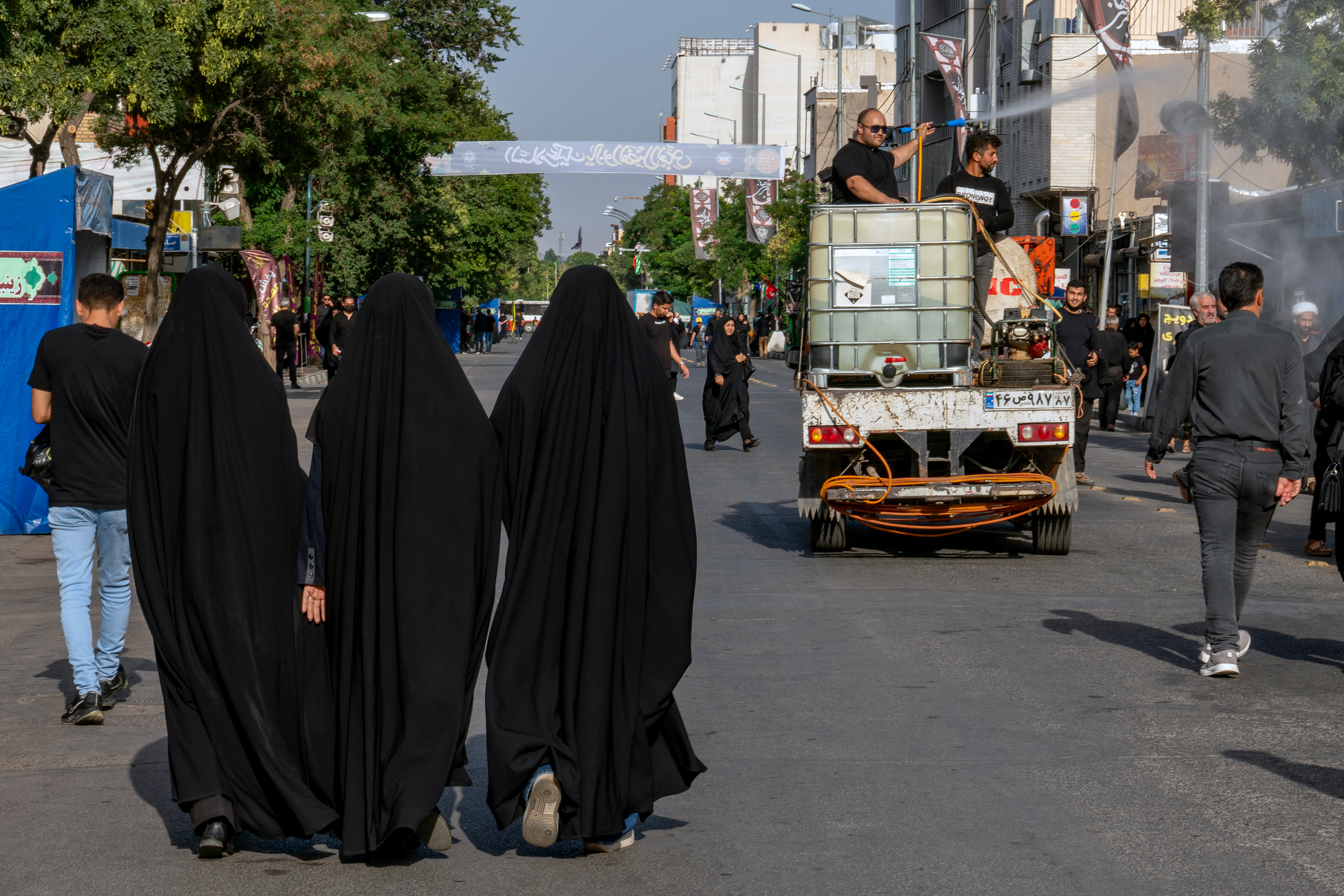 Shiite Muslims in Zanjan walk on the day after Ashura, the 1384th anniversary of Imam Hussein's martyrdom, while Zencan Enghelab Square is cooled with rosewater.