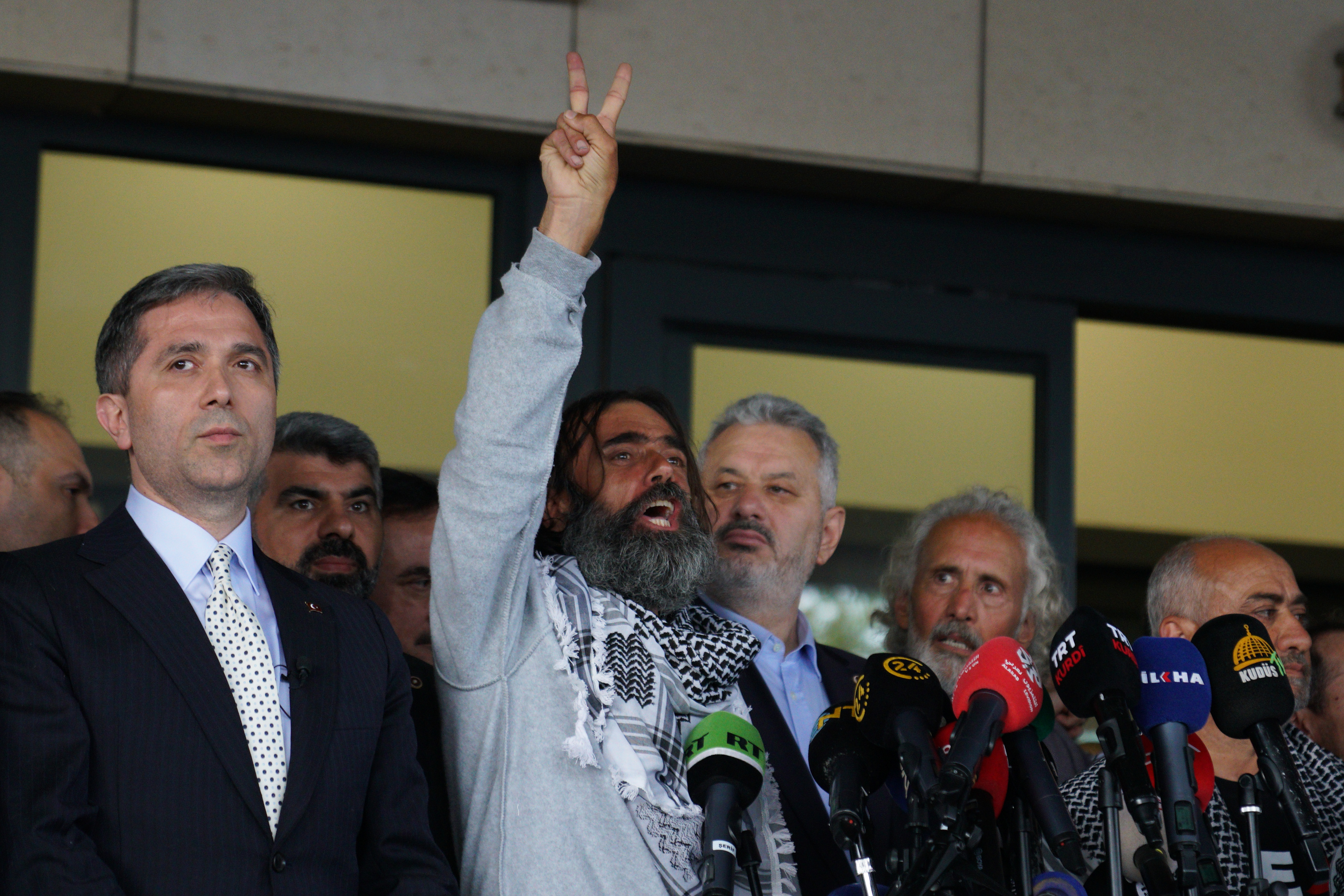 An activist, who was detained aboard the Gaza-bound Global Sumud Flotilla, which was intercepted by Israeli forces, is seen making hand gestures upon arrival as he arrives at Istanbul International Airport after being deported, in Istanbul, Turkey, May 21, 2026.