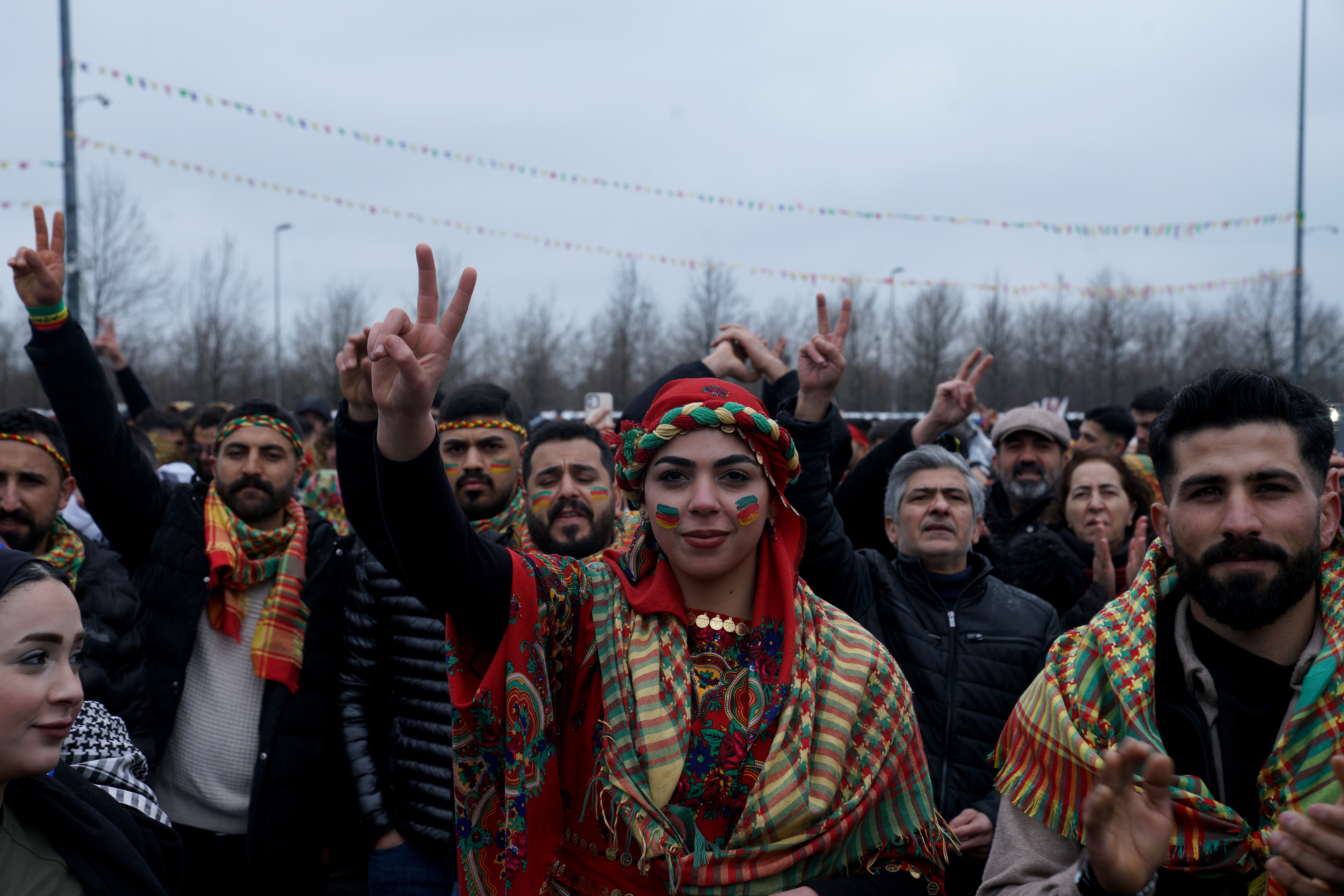 People gesture during a gathering to celebrate the spring festival of Newroz in Istanbul, Turkey, March 22, 2026.