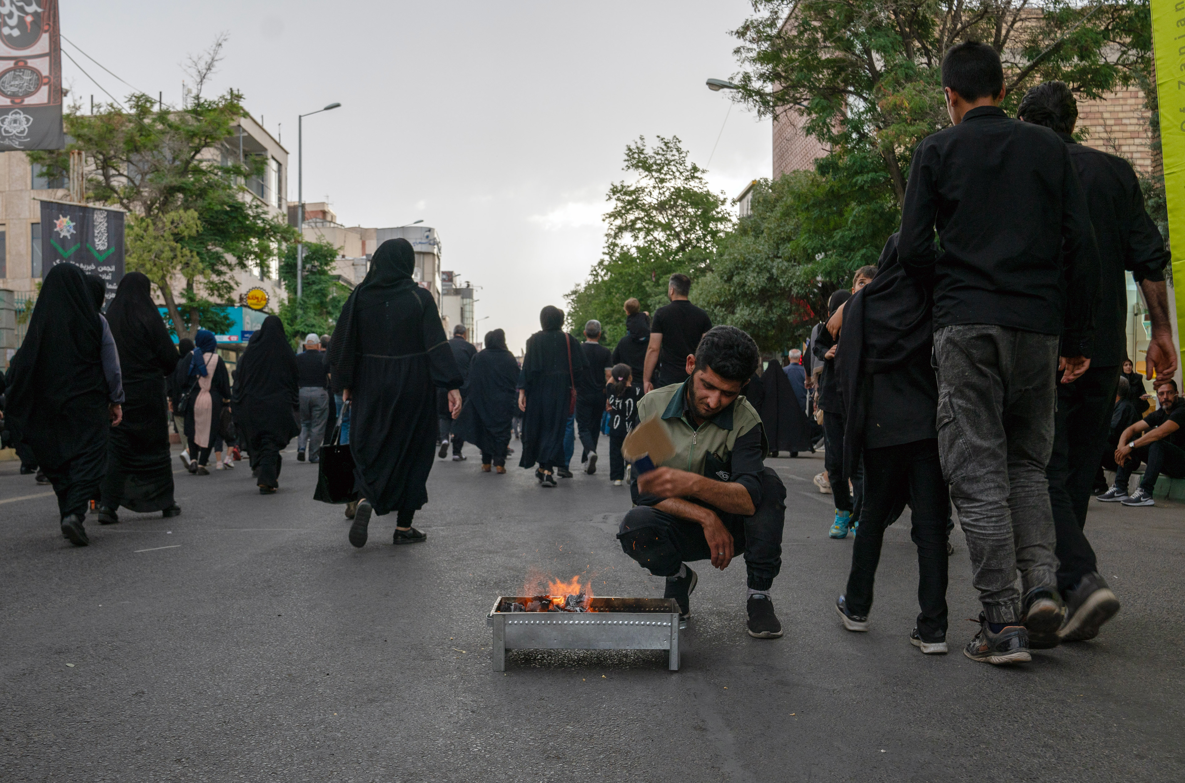 A man lights a fire at Enghelab Square in Zanjan to avoid the evil eye, the day after the Day of Ashura, the 1384th anniversary of Imam Hussein's martyrdom.