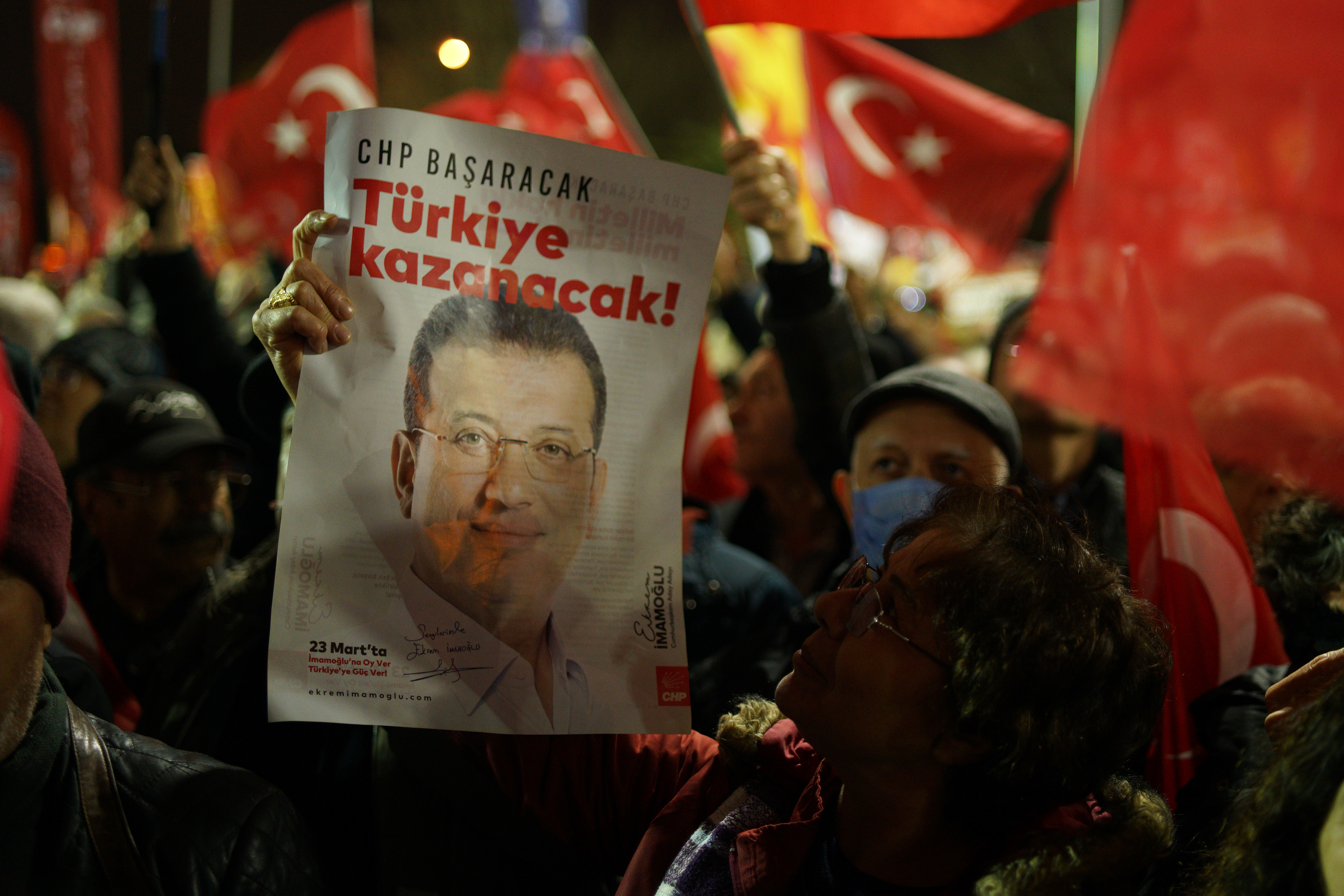 A person holds a placard with the picture of Istanbul Mayor Ekrem Imamoglu outside the Istanbul Metropolitan Municipality building  during a rally to protest the first anniversary of the arrest of Istanbul Mayor Ekrem Imamoglu, the mayor of Istanbul in Istanbul, Turkey on March 18, 2026.